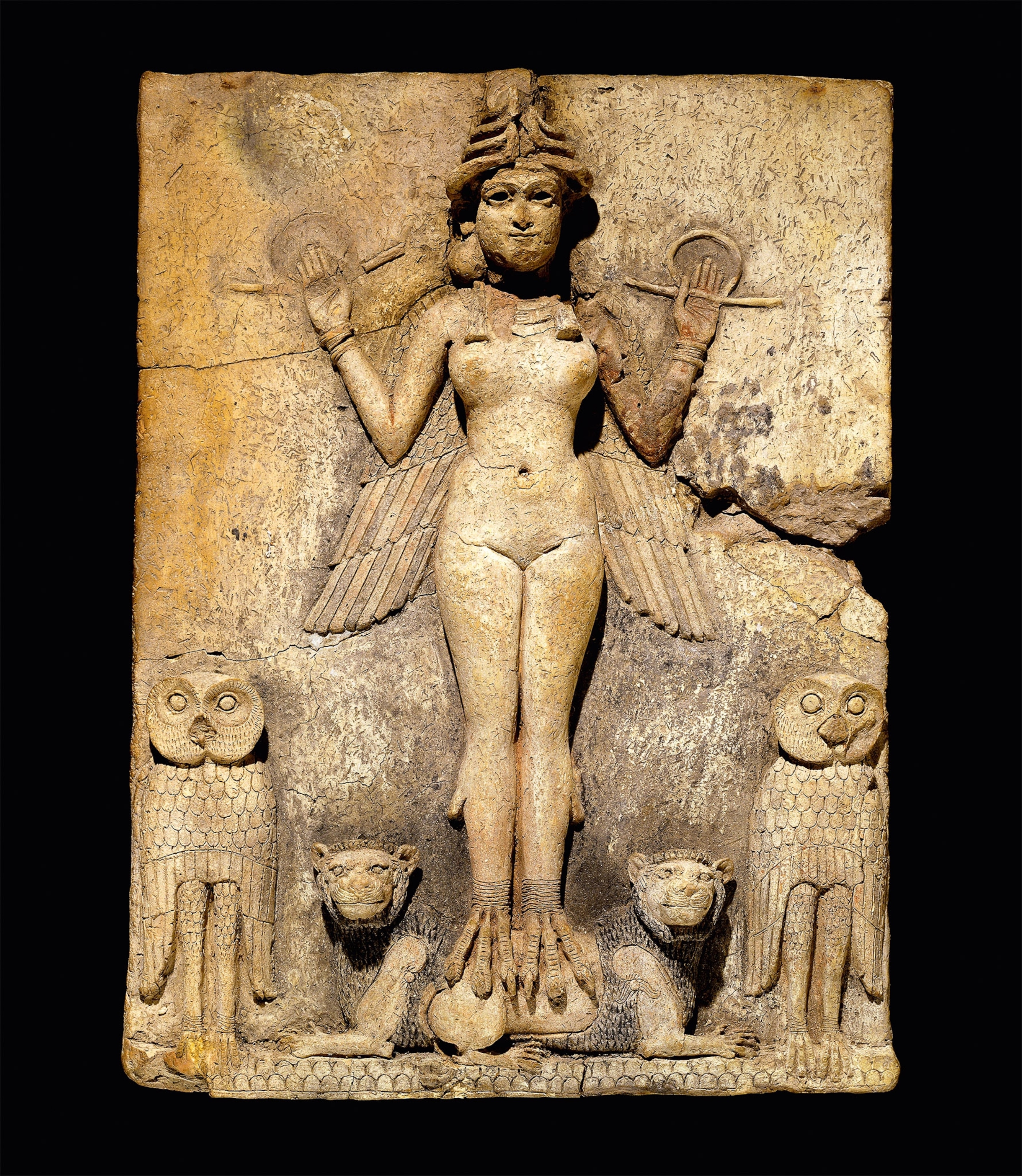 A clay plaque depicts a goddess with wings flanked by owls