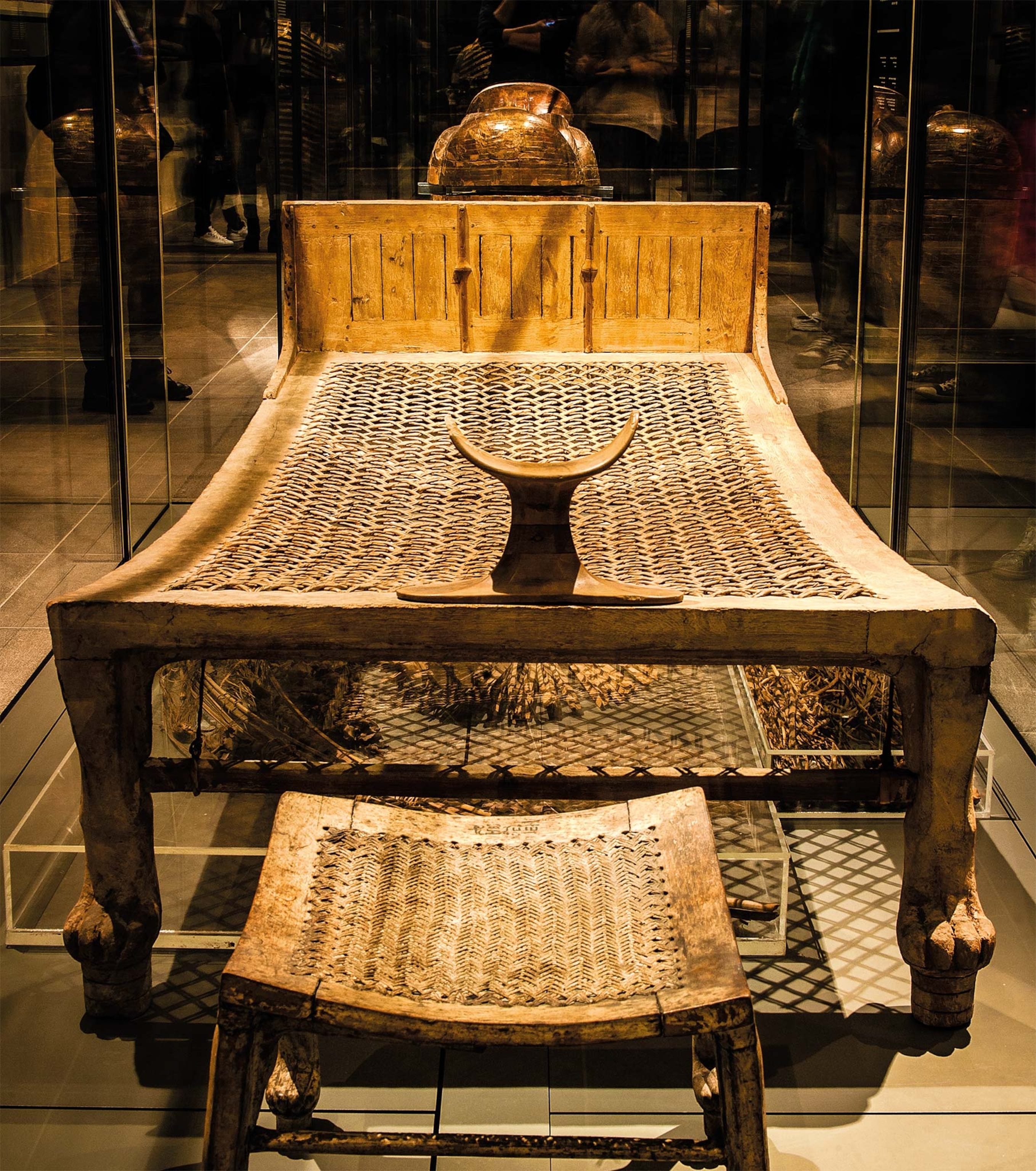 A bed with a supporting ned, wooden frame, and four posts in the shape of lions legs is on display at a museum