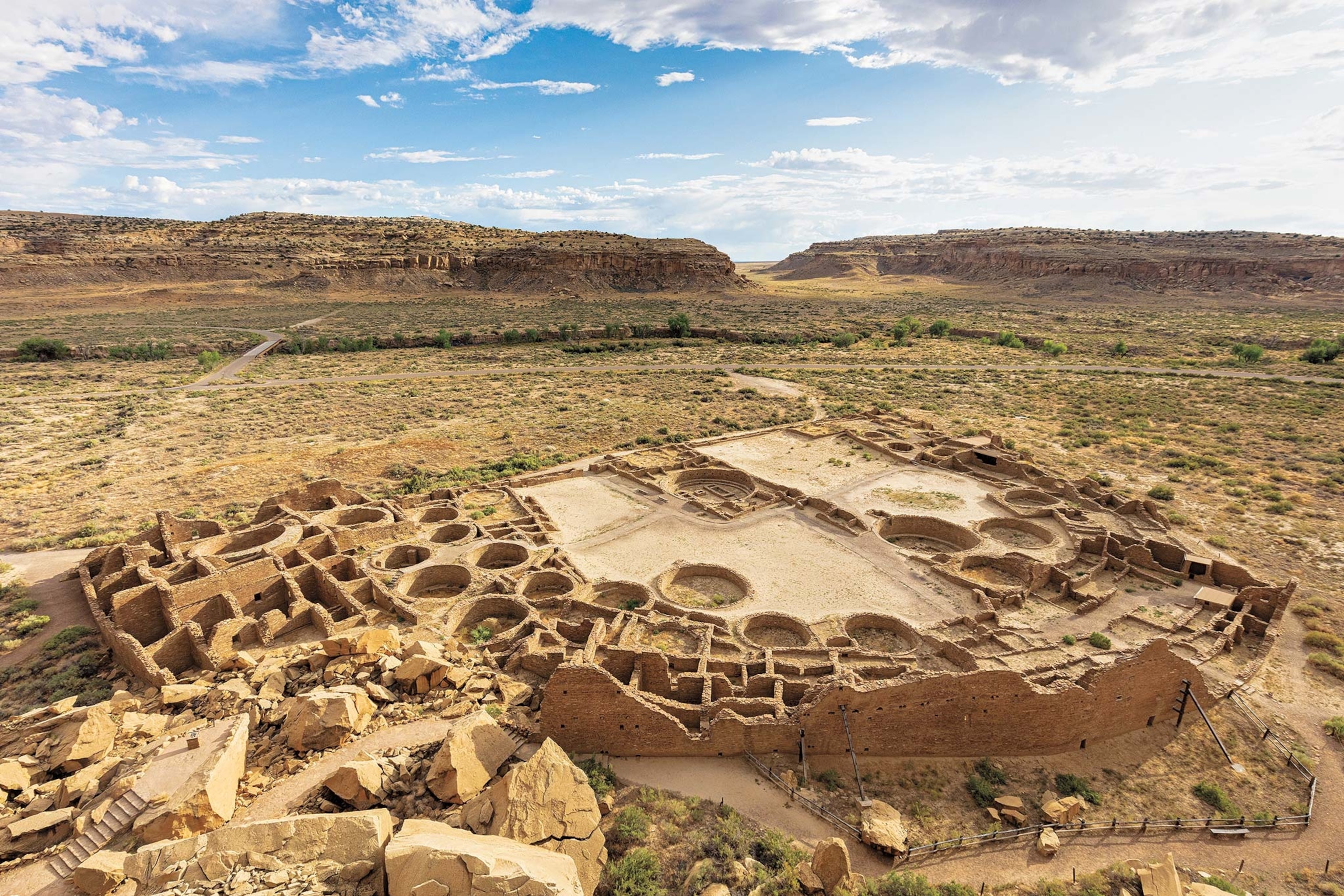 An aerial view of Chaco Canyon's ceremonial kivas, or chambers, with red rocks in the distance