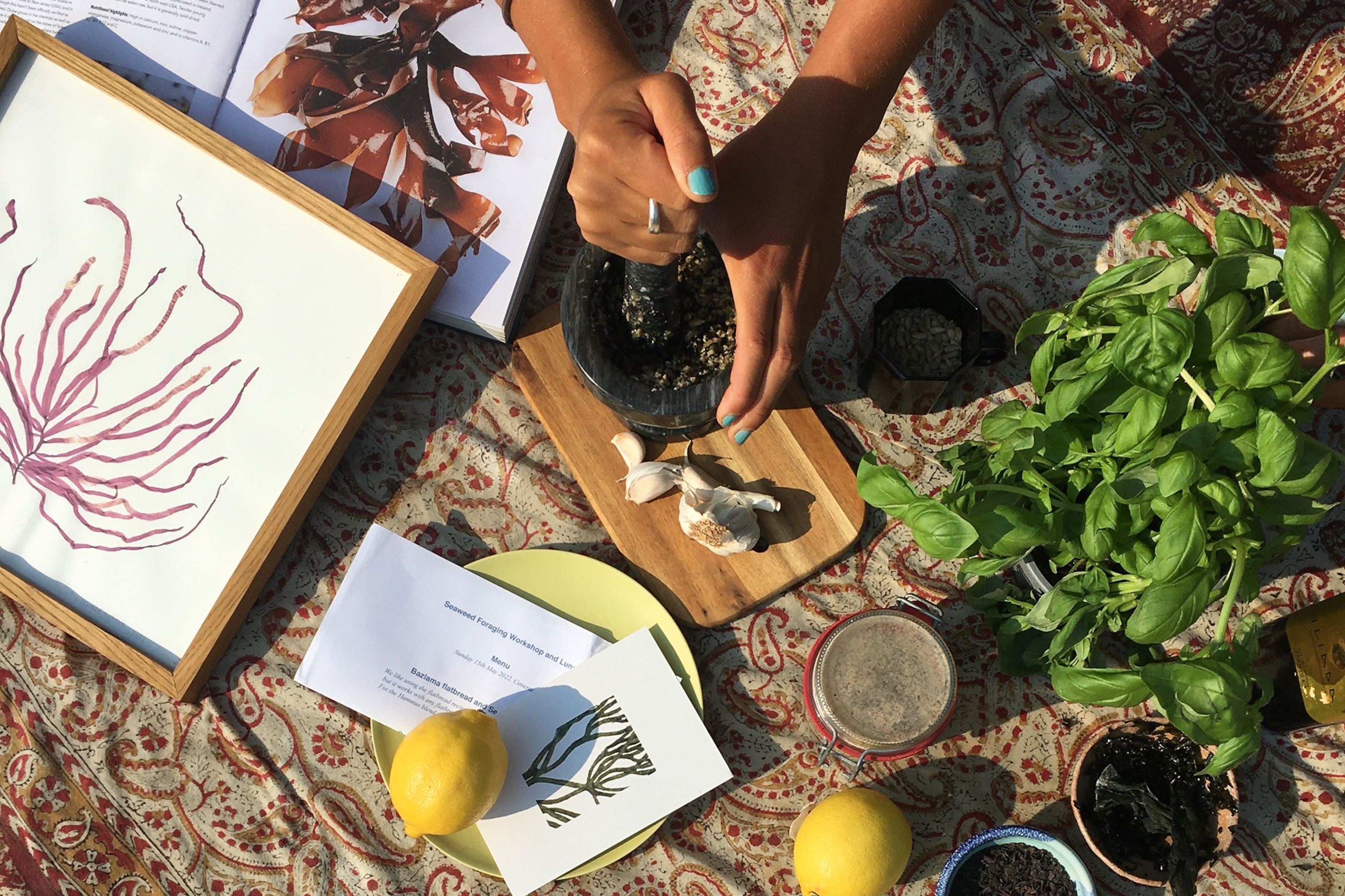 Books about seaweed and fresh ingredients including lemon and basil on a table.