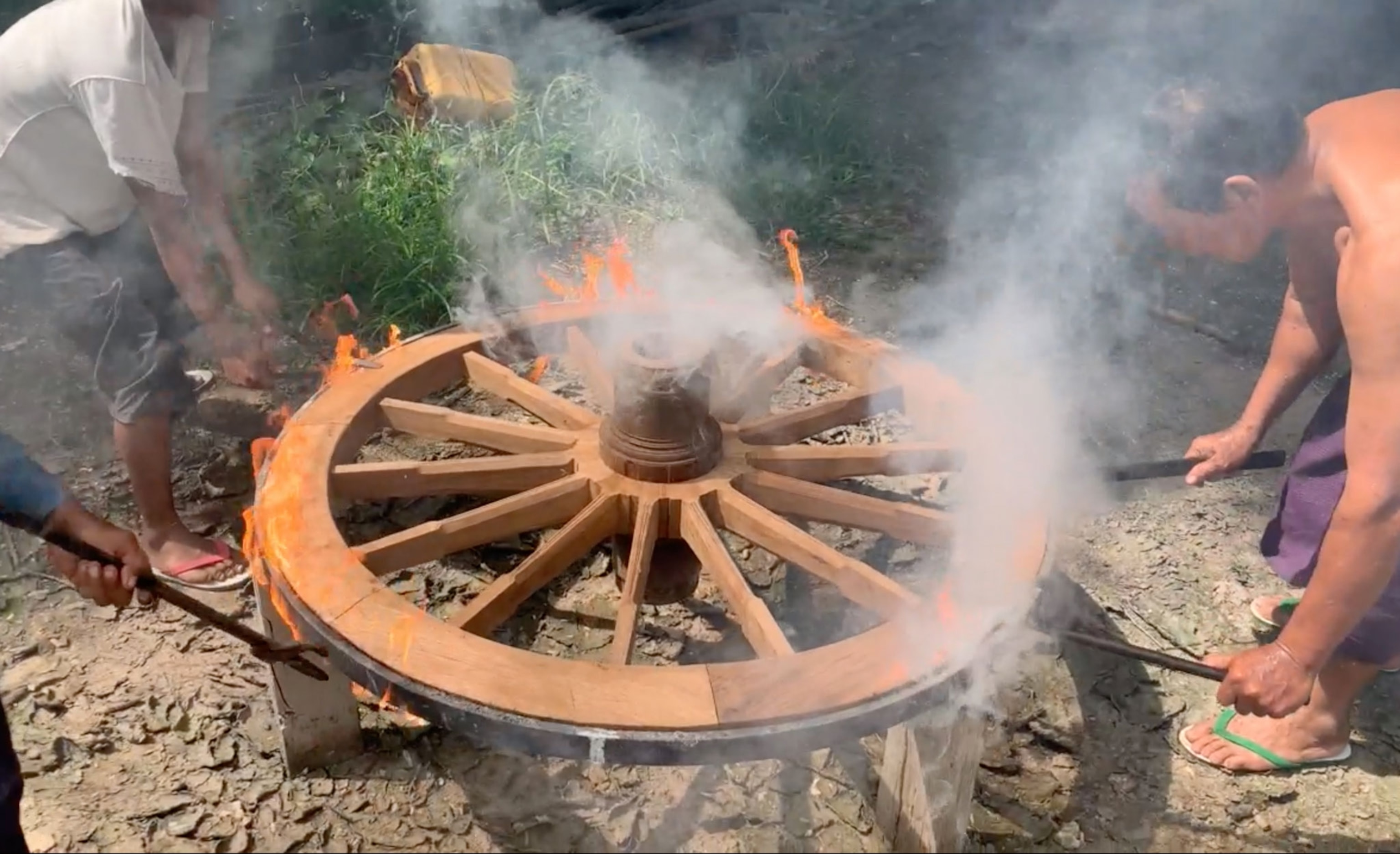 A wooden wheel burns when the hot metal circle is placed around it