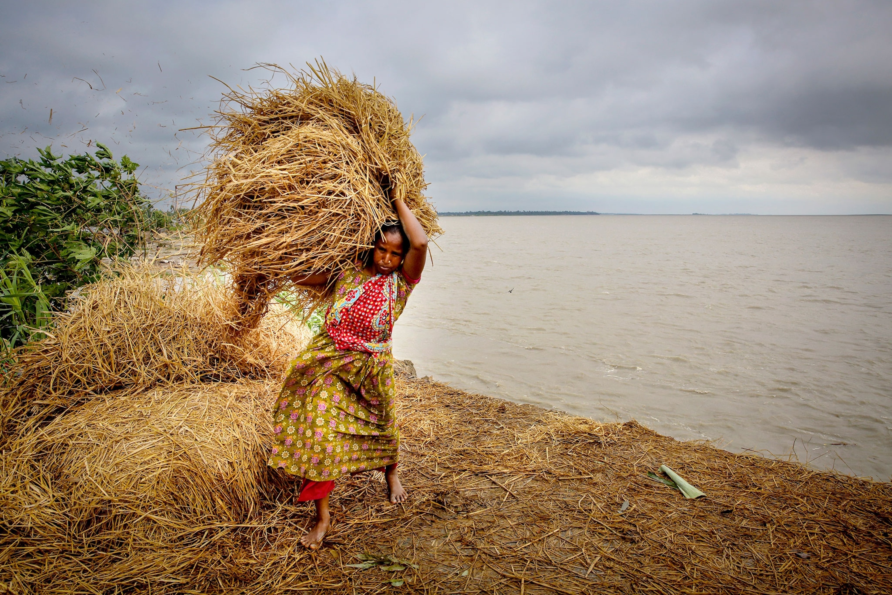 a woman moving hay away from rising water