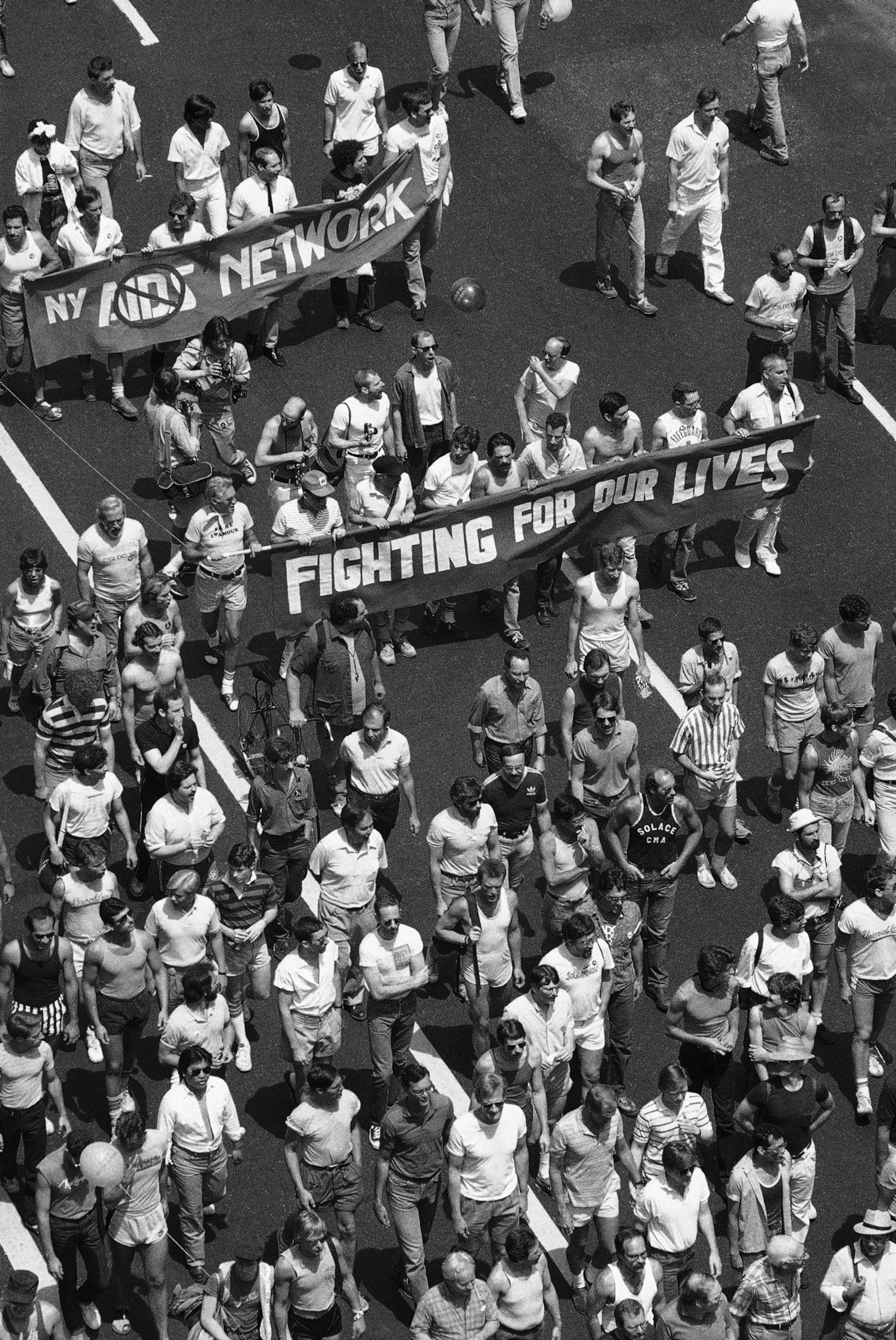 a black and white photo from a high vantage point looking down on marchers on the street