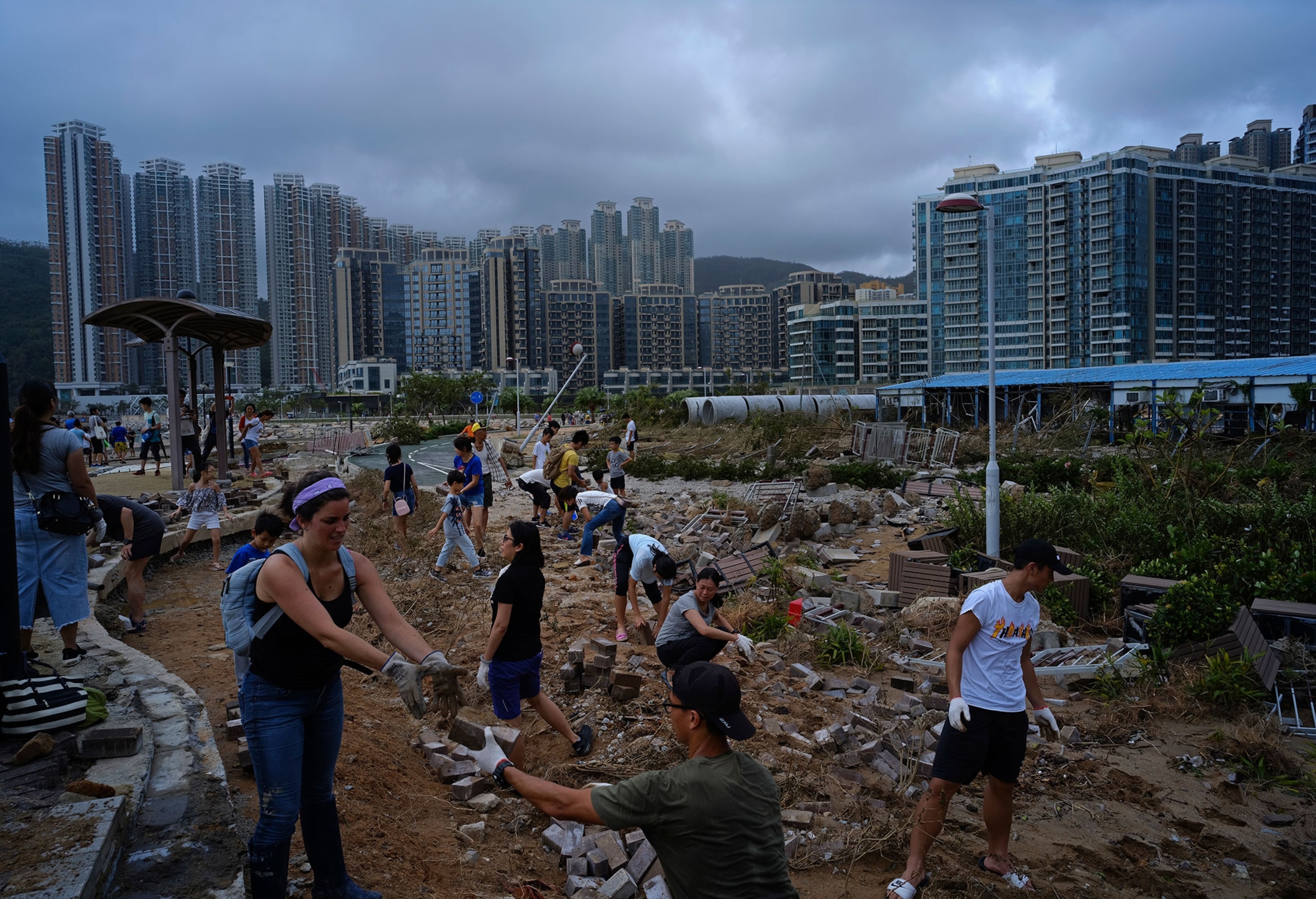 people helping to clean debris left behind by Typhoon Mangkhut.