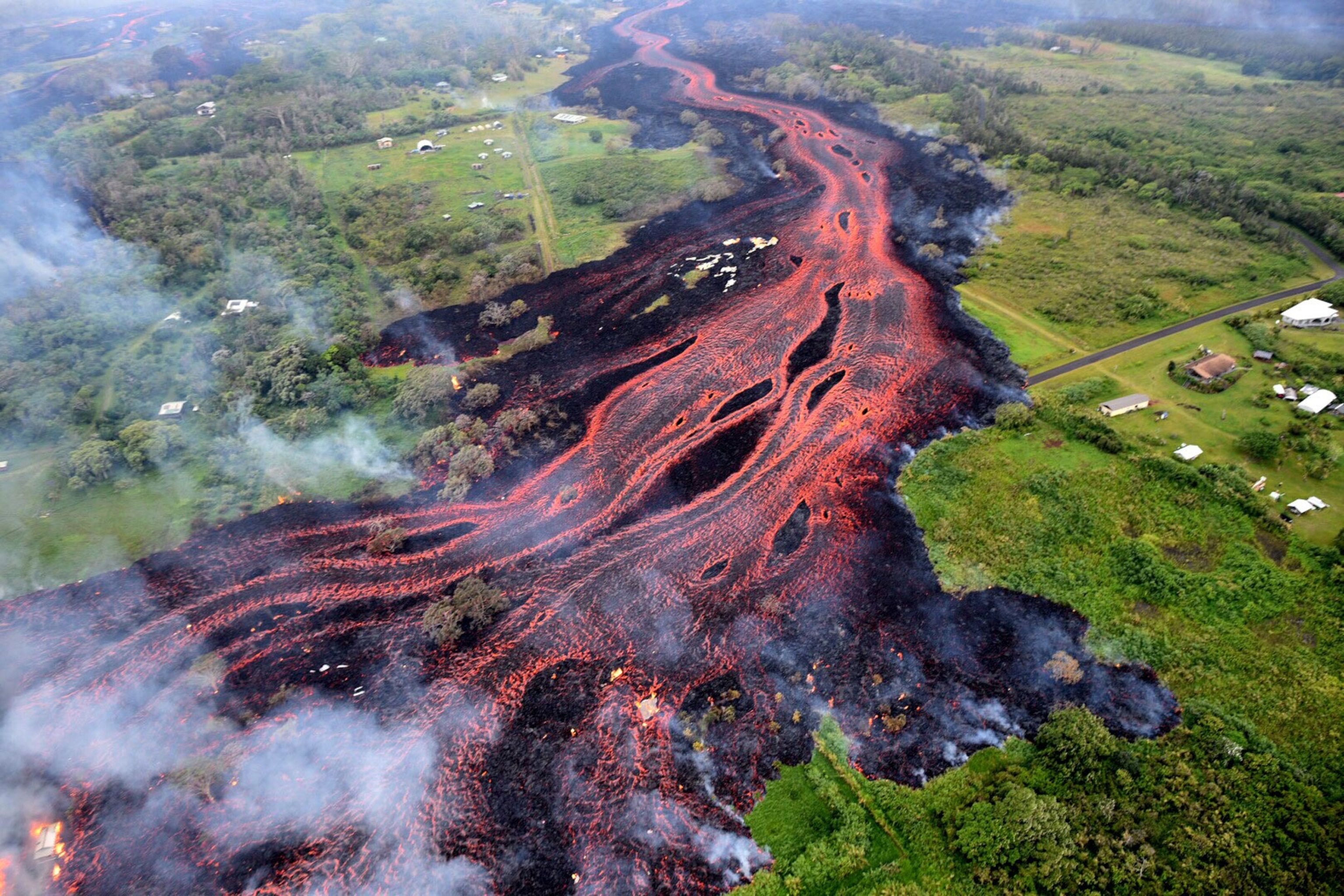 Ash plume rises from forest following a massive volcano eruption on Kilauea volcano in Hawaii, United States on May 22, 2018.