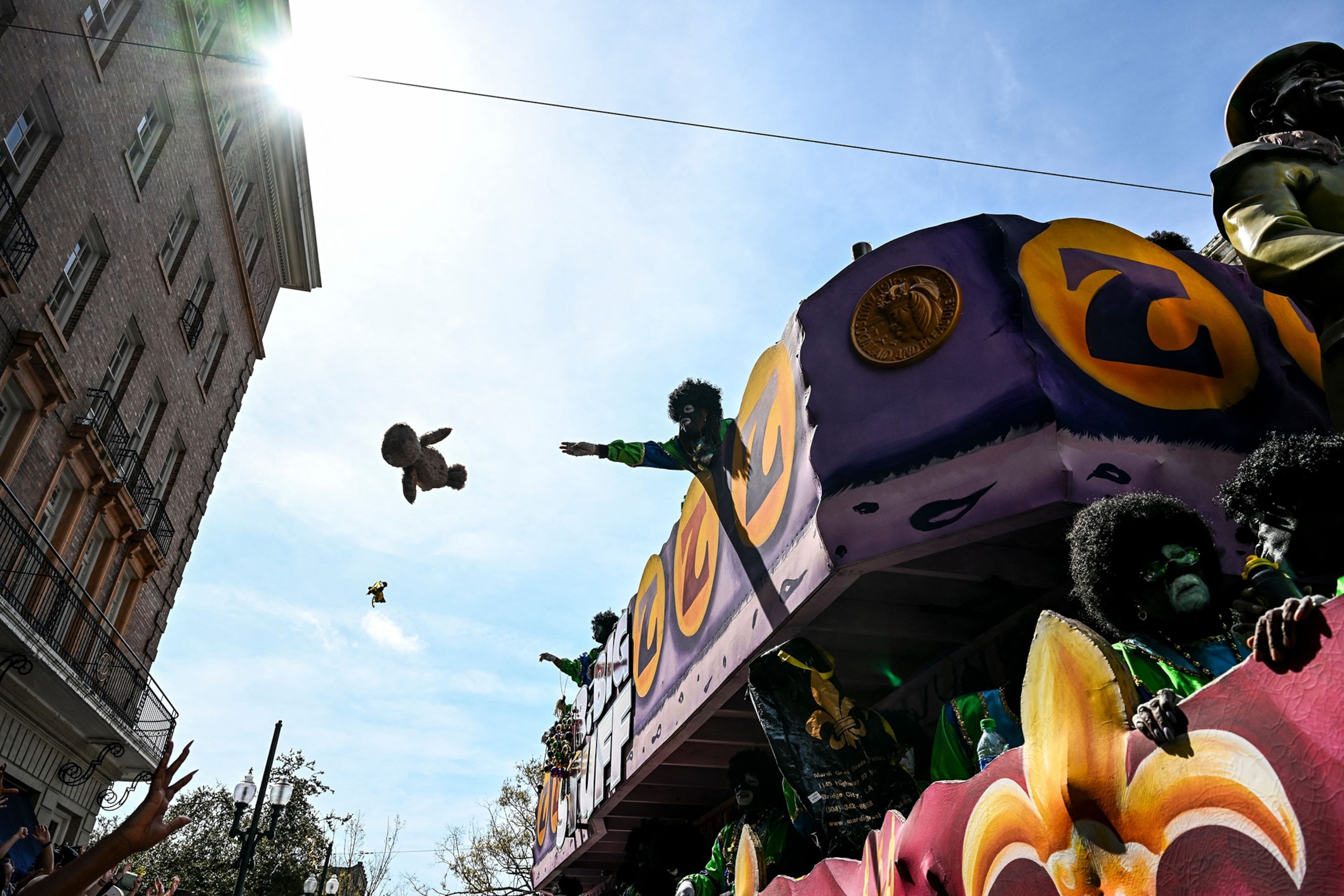 Revellers catch objects from a float in the 2023 Zulu Social Aid and Pleasure Club parade during a Mardi Gras celebration in New Orleans, Louisiana.