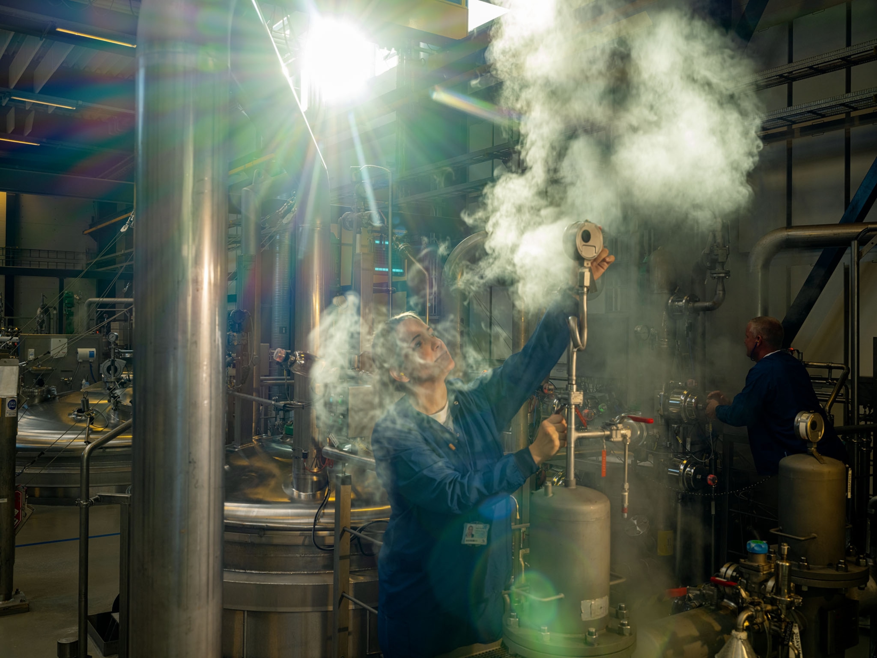 a woman in blue, surrounded by machinery, working in a factory