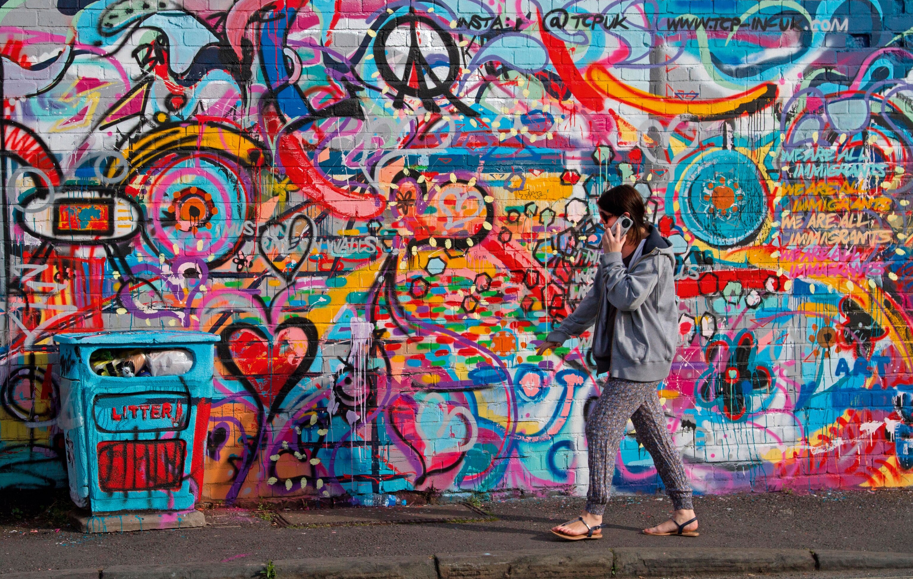 woman walking before wall of street art