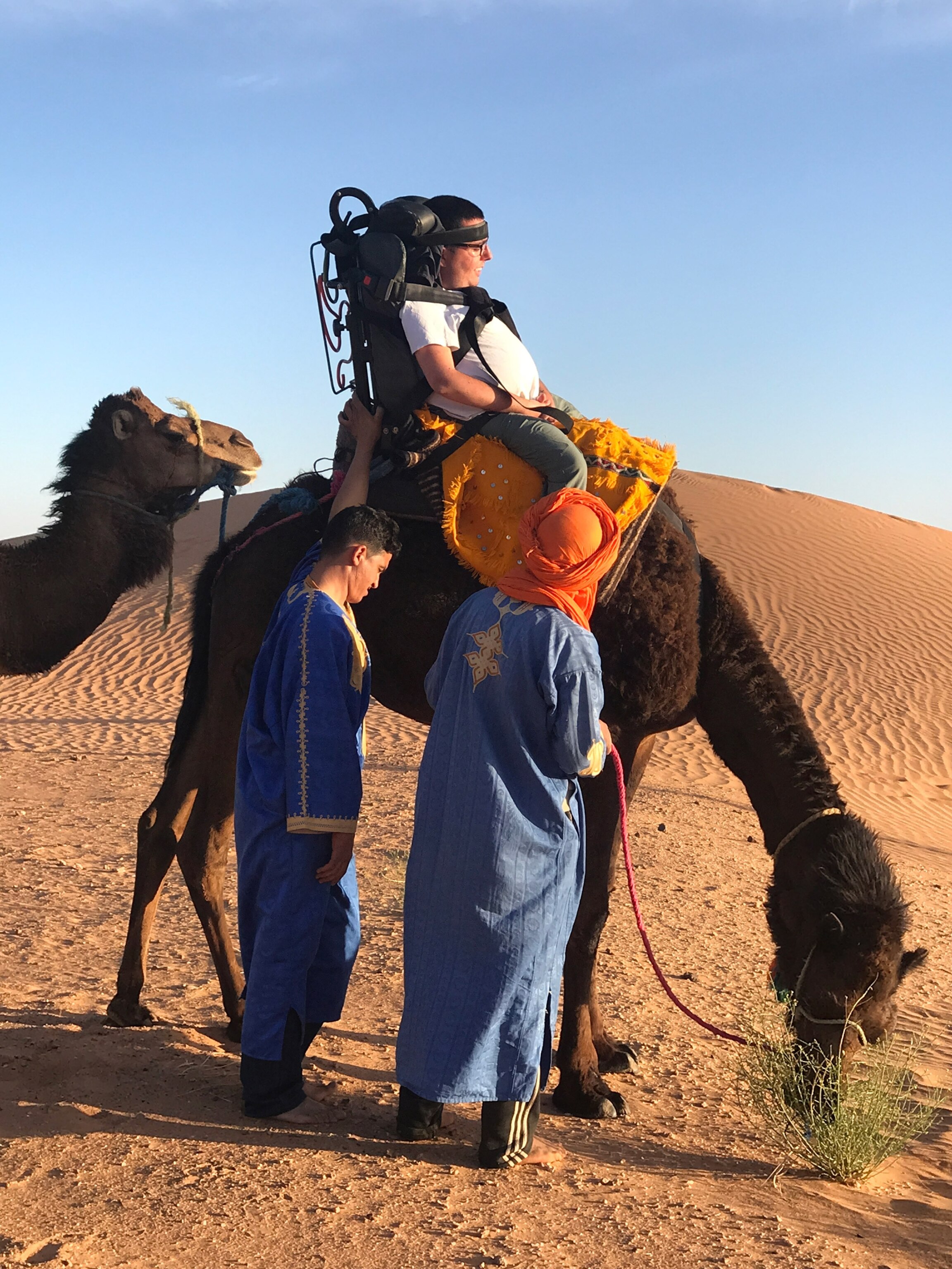 a person riding a camel using an accessible saddle in Morocco