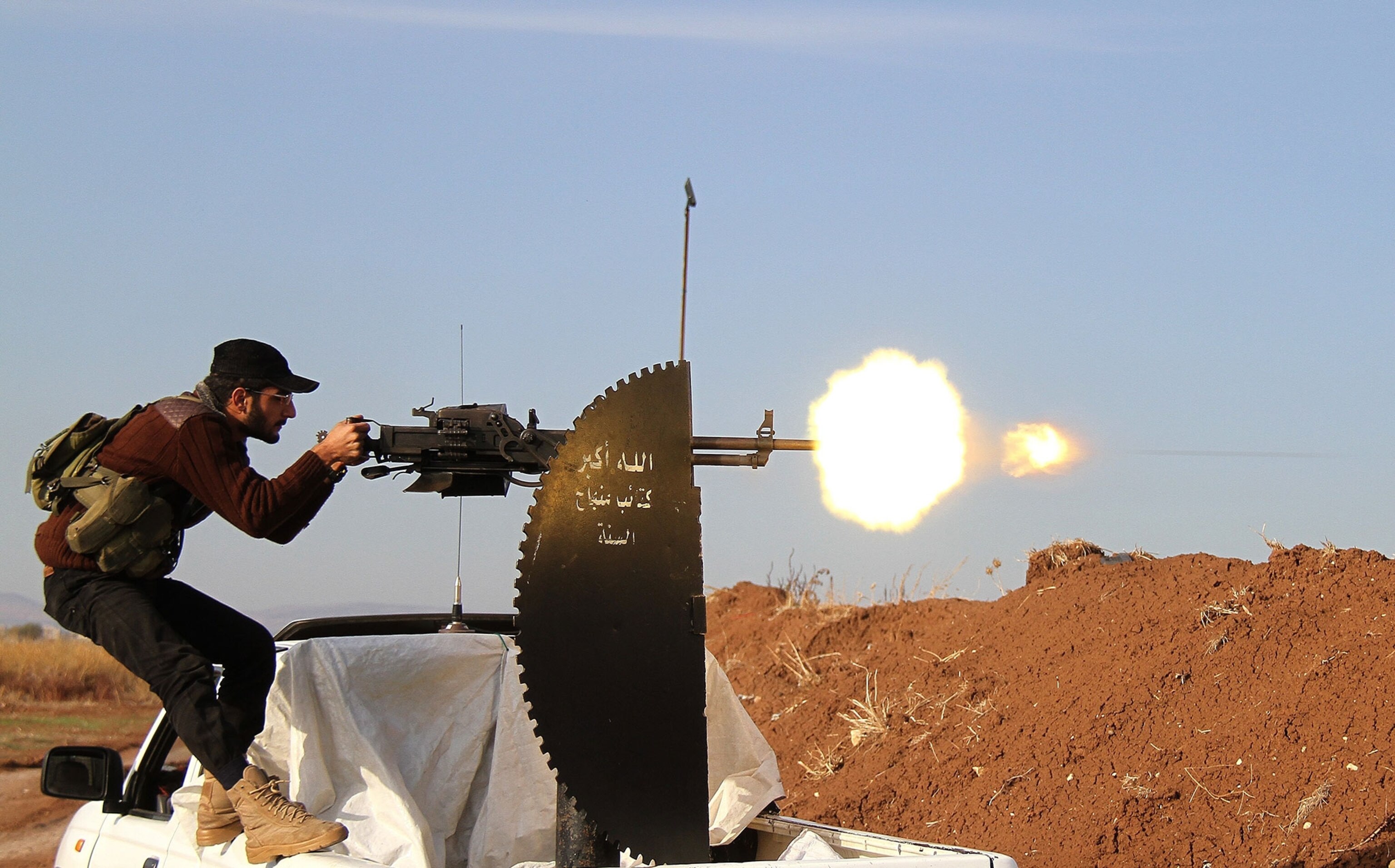 man firing machine gun