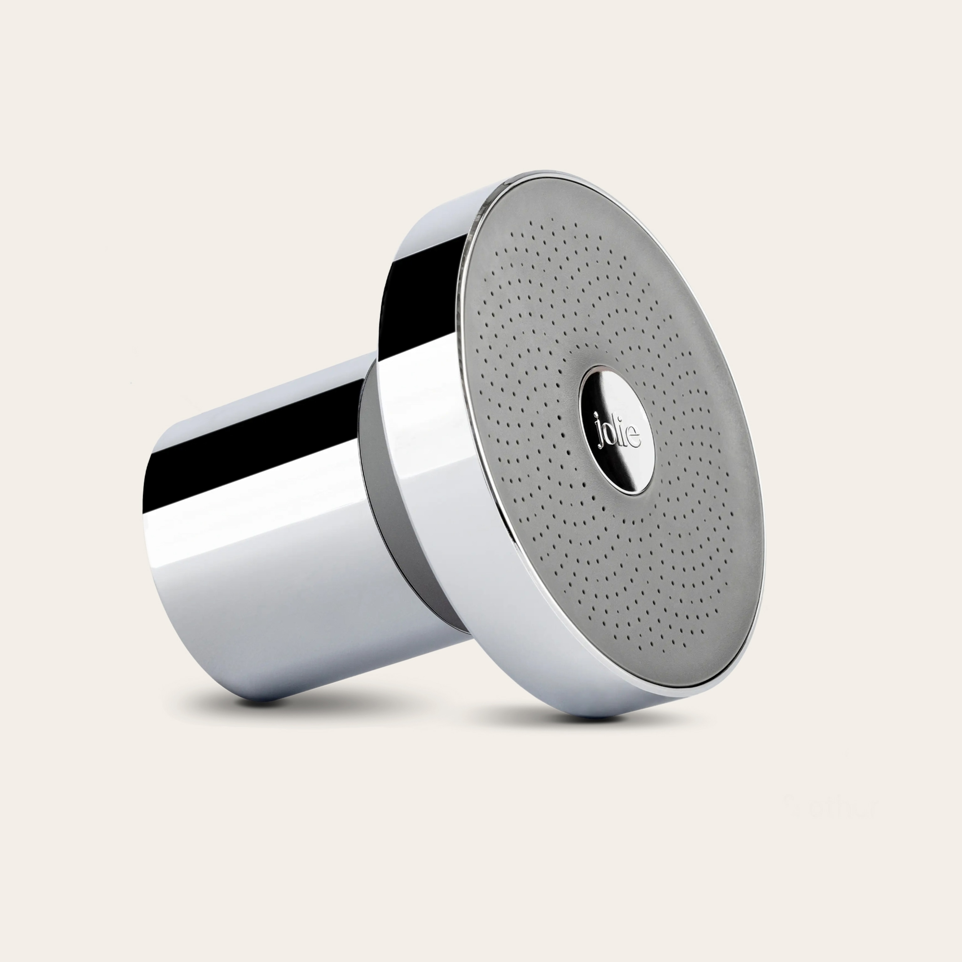 A metal shower head against a tan background.