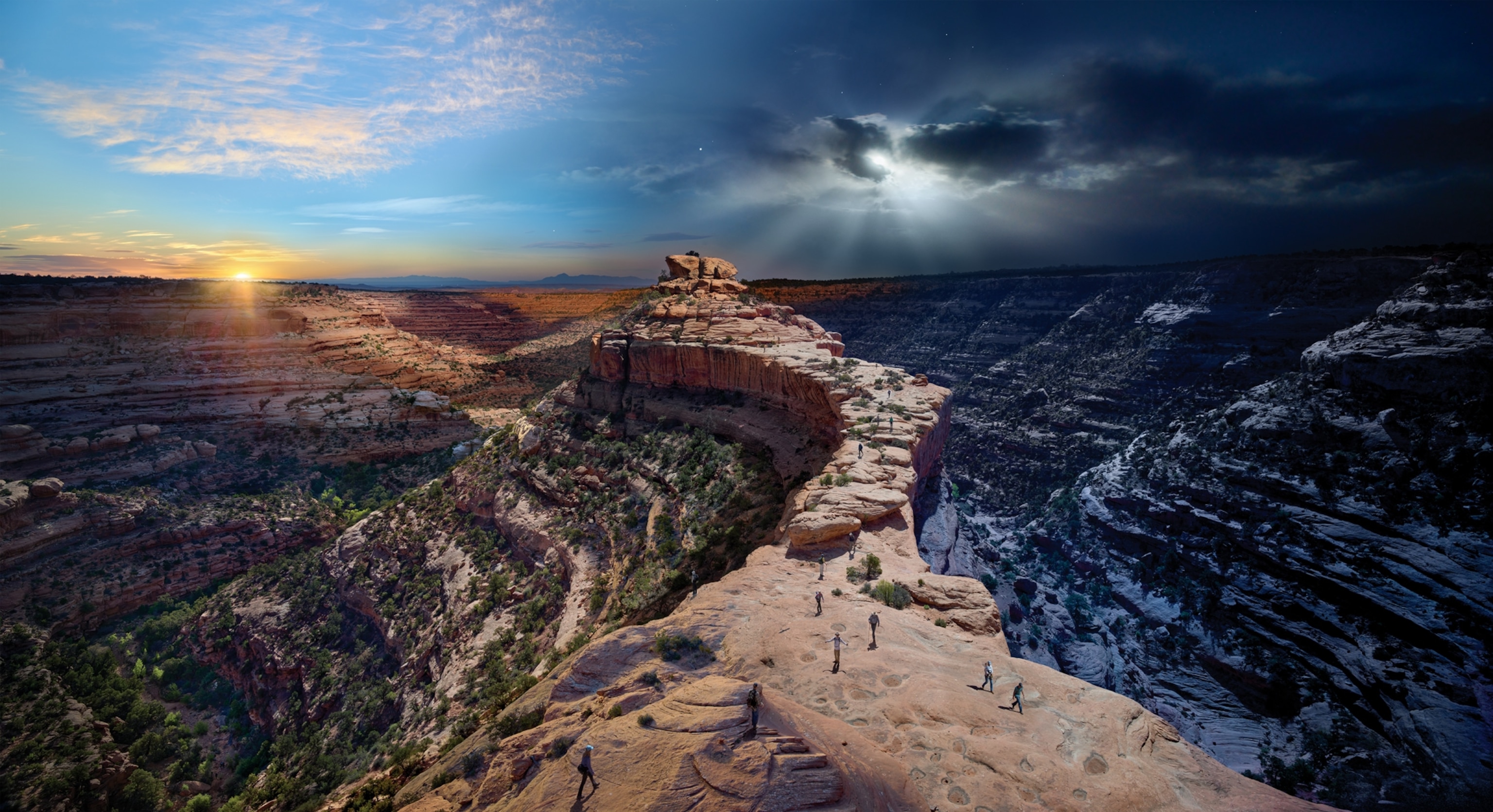 Picture of a pair of towering buttes stand against beautiful scenery with sunrise on the left and sunset on the right.