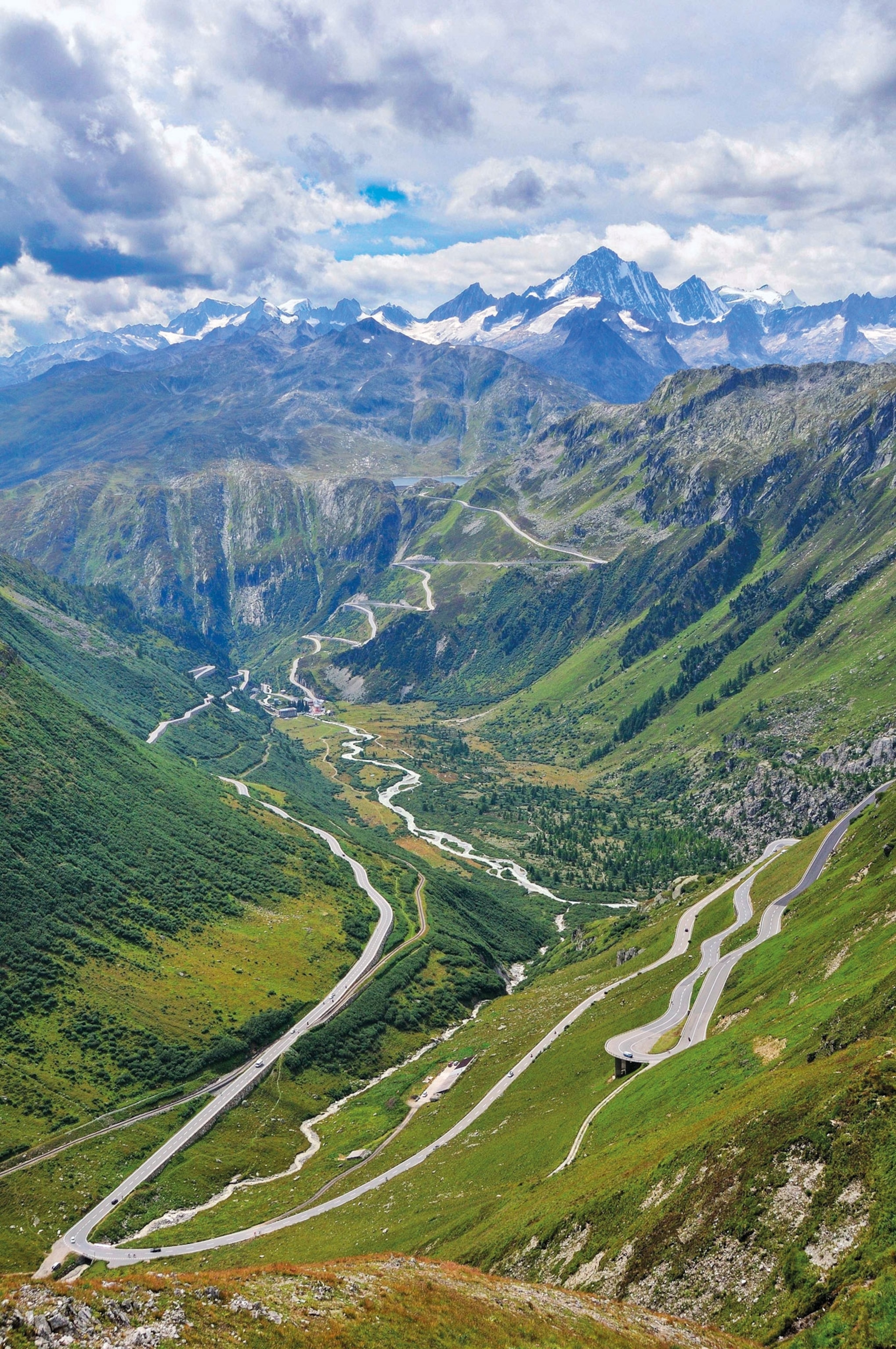 A landscape with high mountains and a green valley