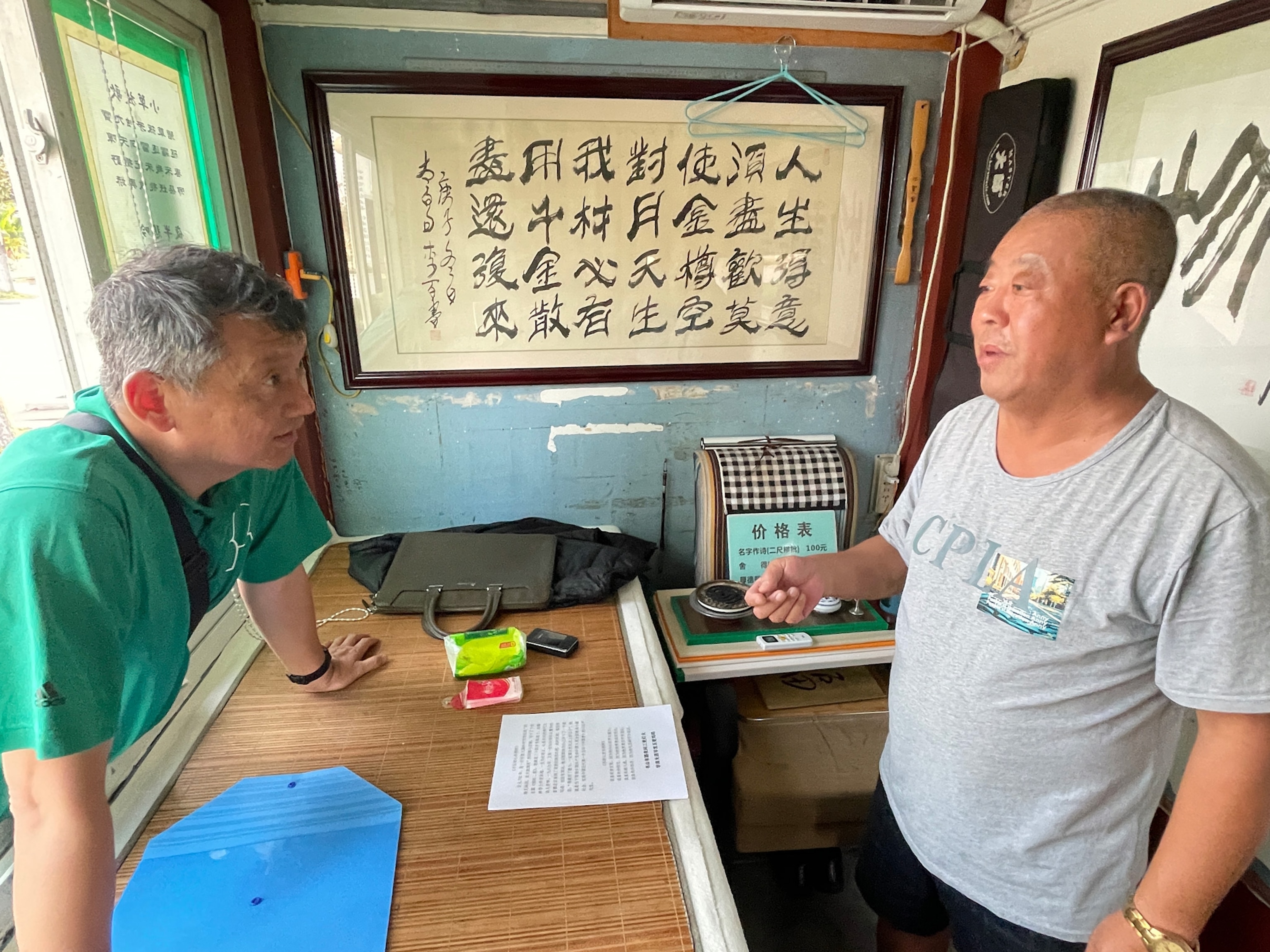 Photo of two man talking in small booth