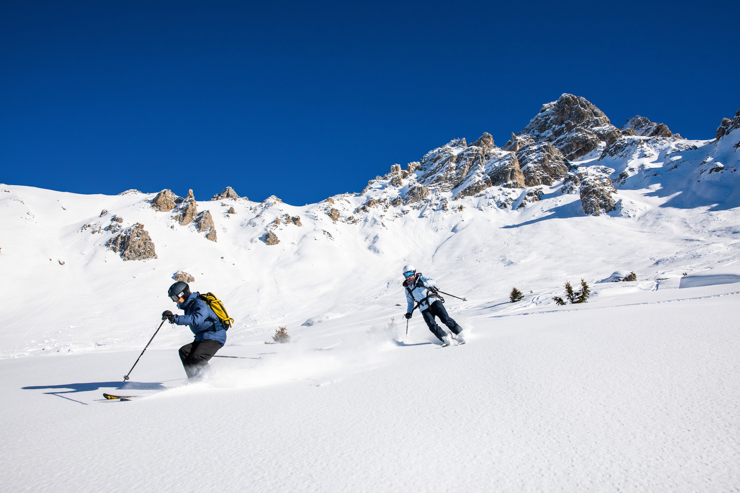 pair skiing down mountain side