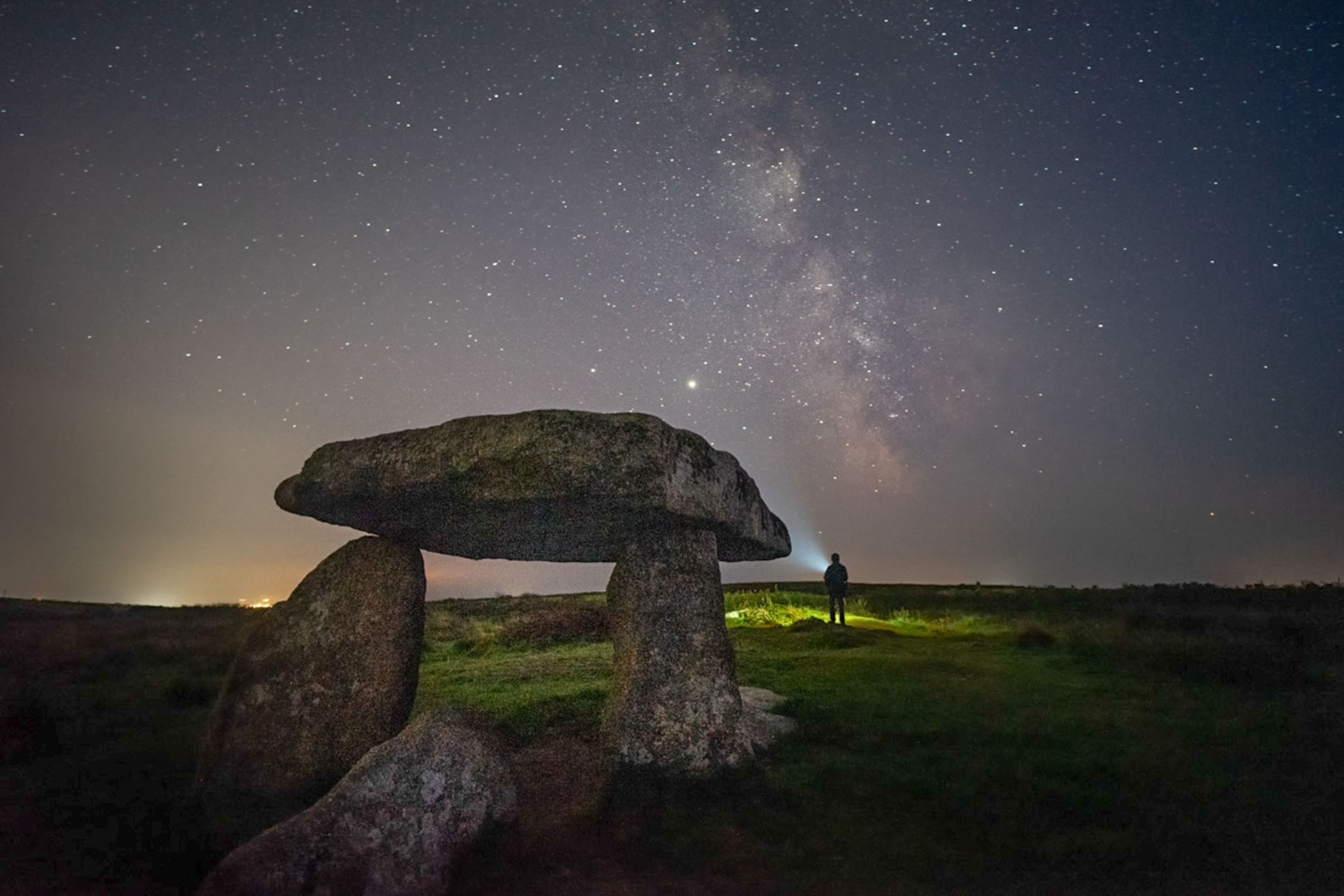 the Milky Way seen in the night sky with a stone structure known as Lanyon Quoit in the foreground