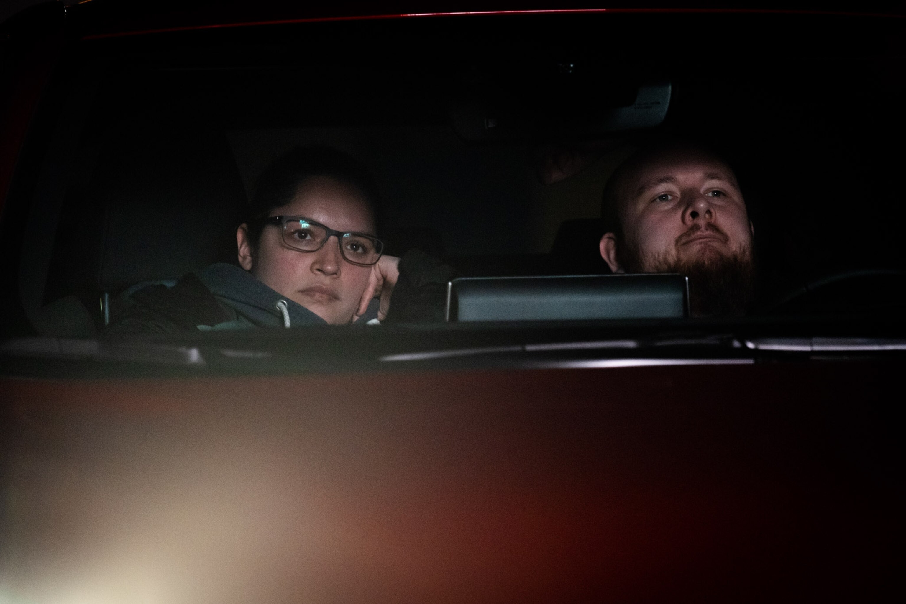 a man and woman in their car watching a movie at a drive in theatre