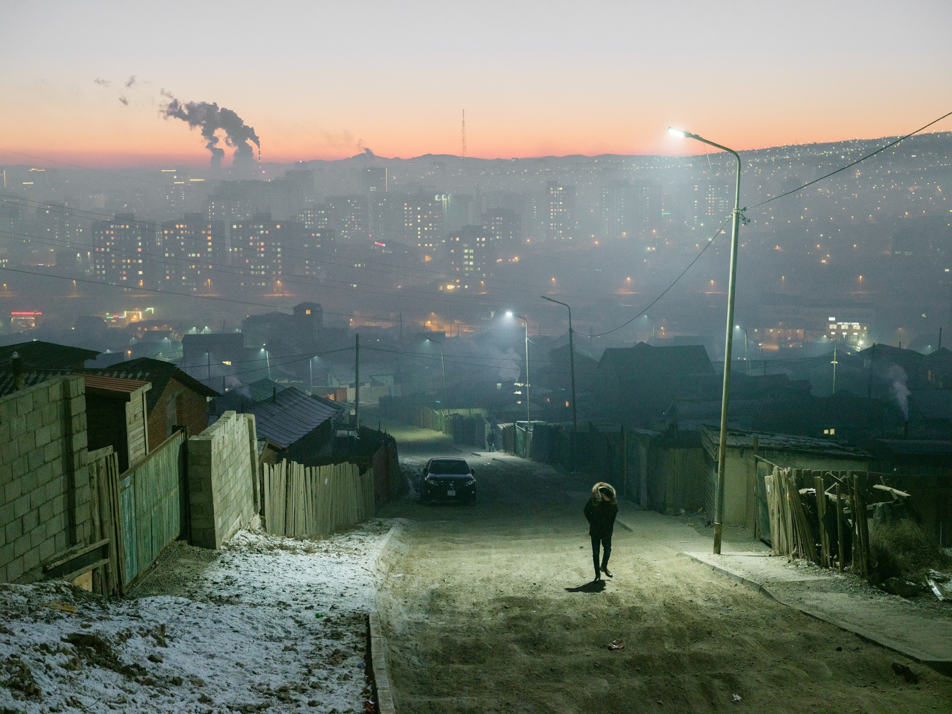 Picture of man town street at winter night with heavy smog over city on background.