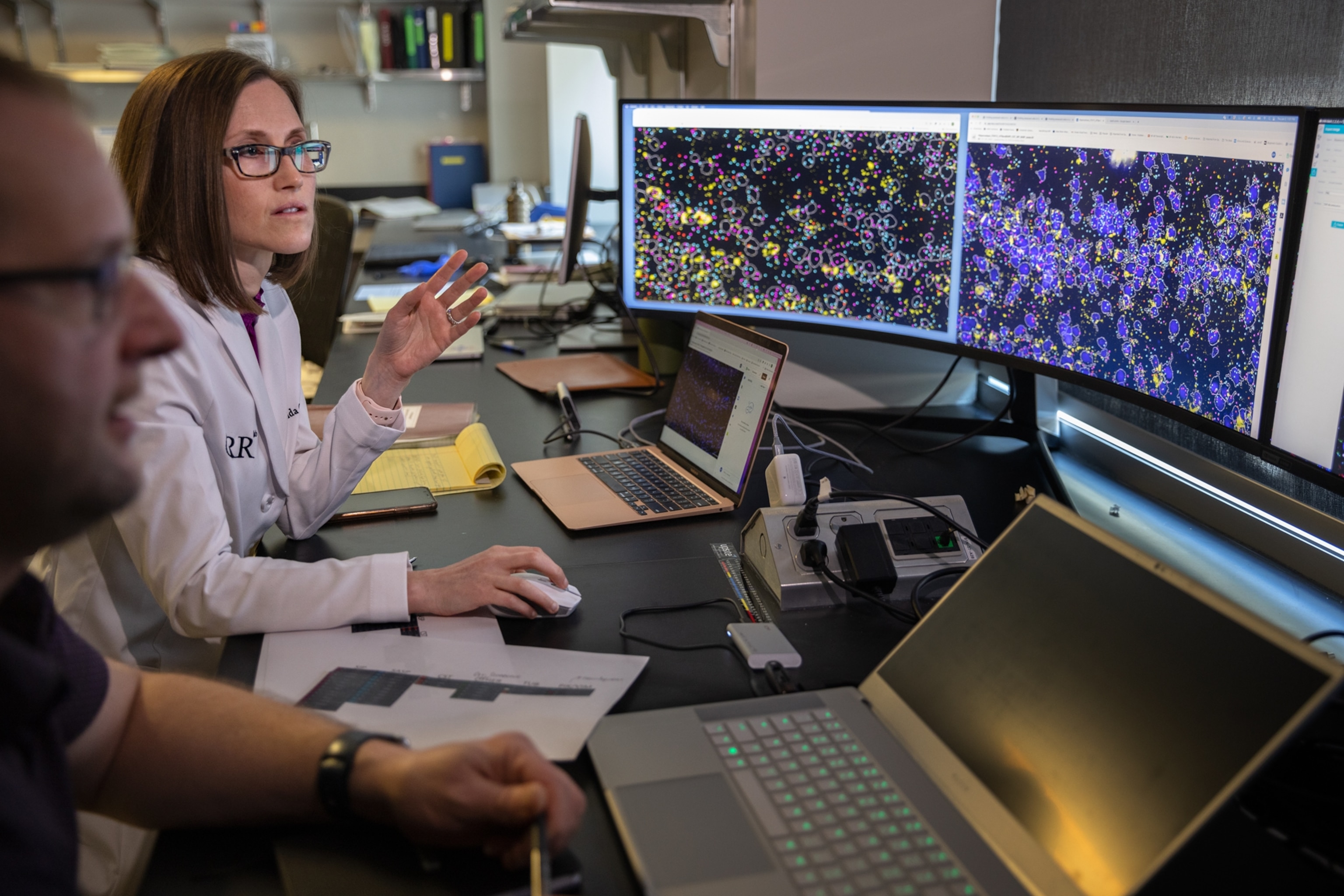 Picture of woman and man discuss imagers on computer screens.