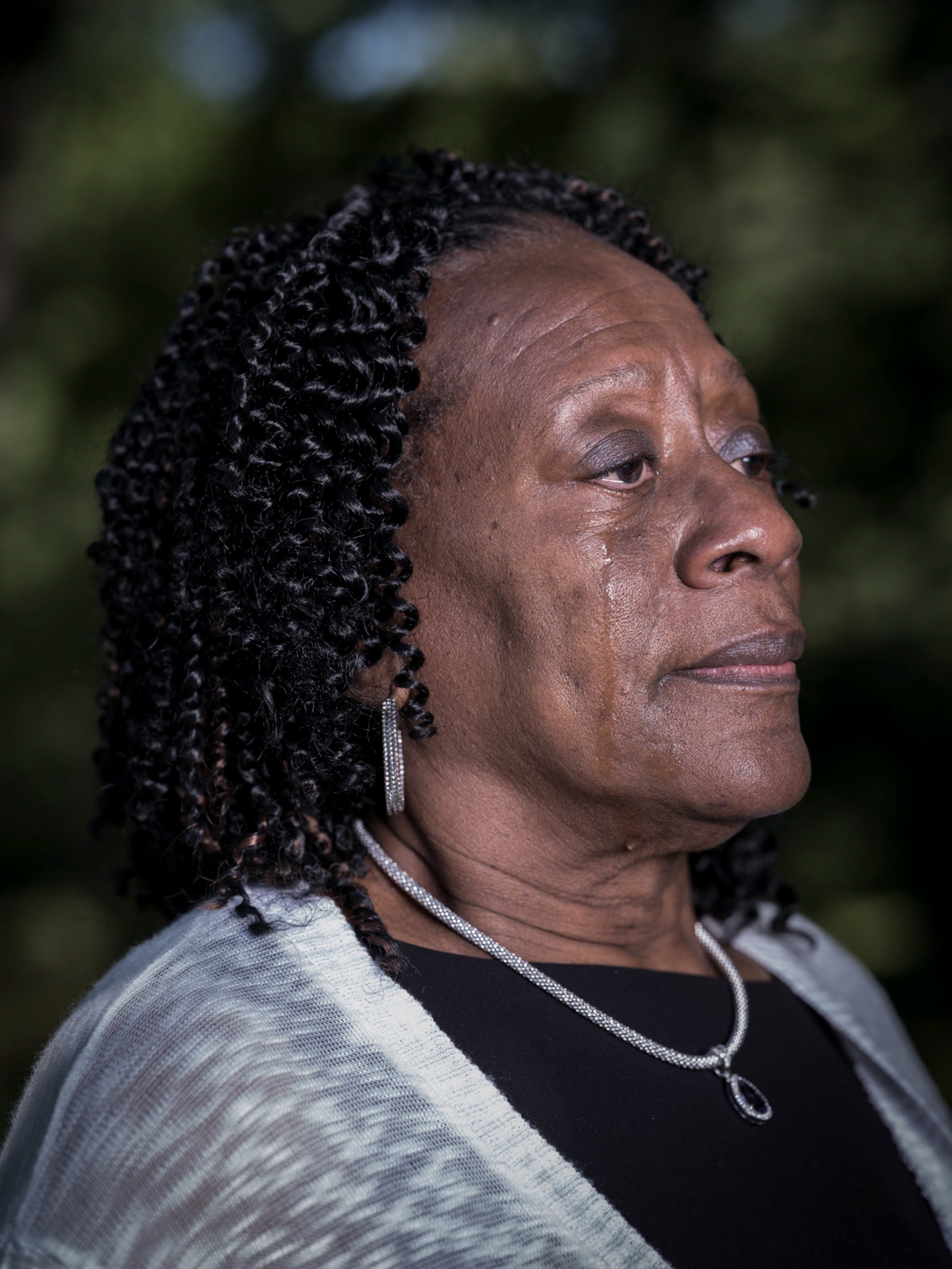 a woman cries mourning her husbands death in Detroit
