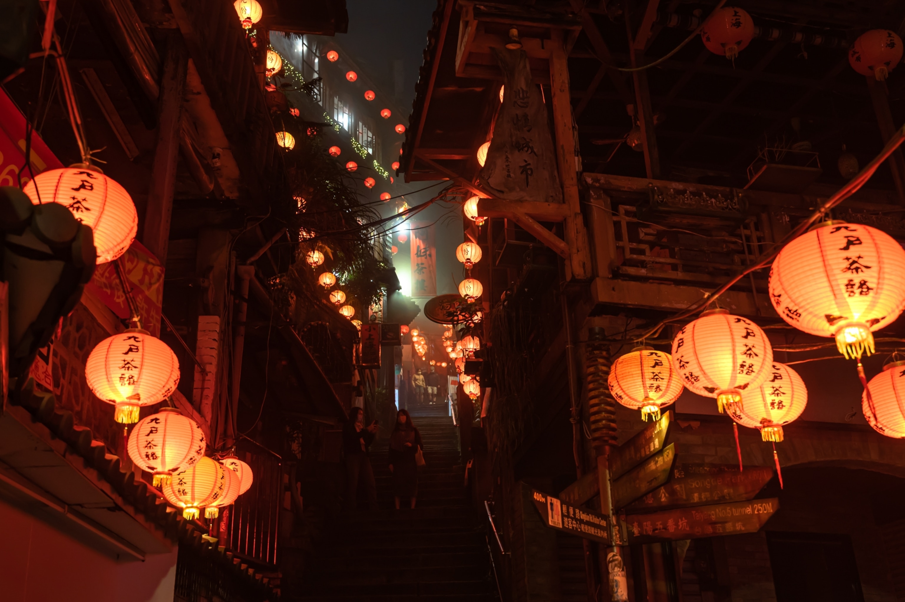 Visitors explore Jiufen’s tight winding alleyways lit by traditional hanging lanterns