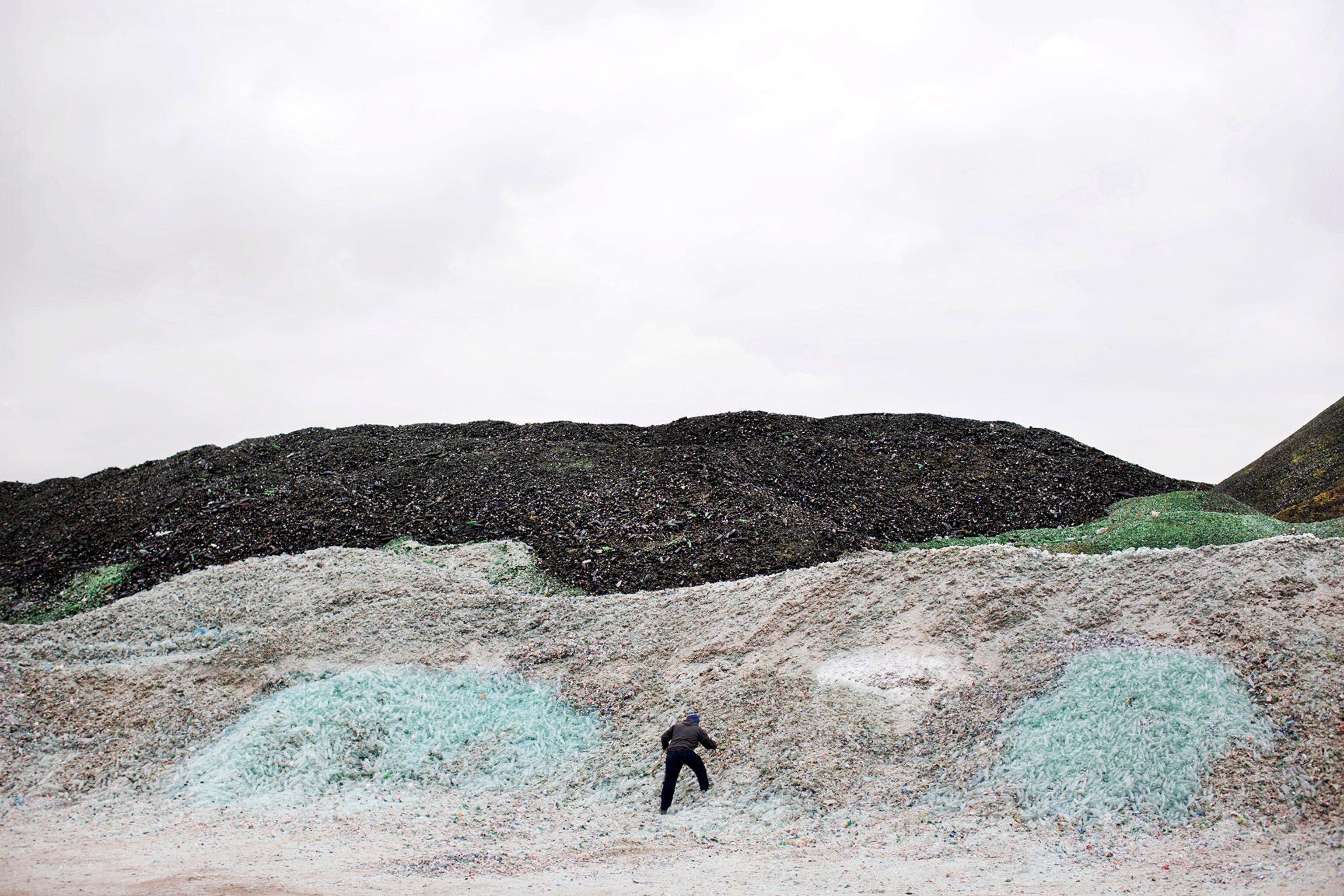 a factory worker among piles of glass