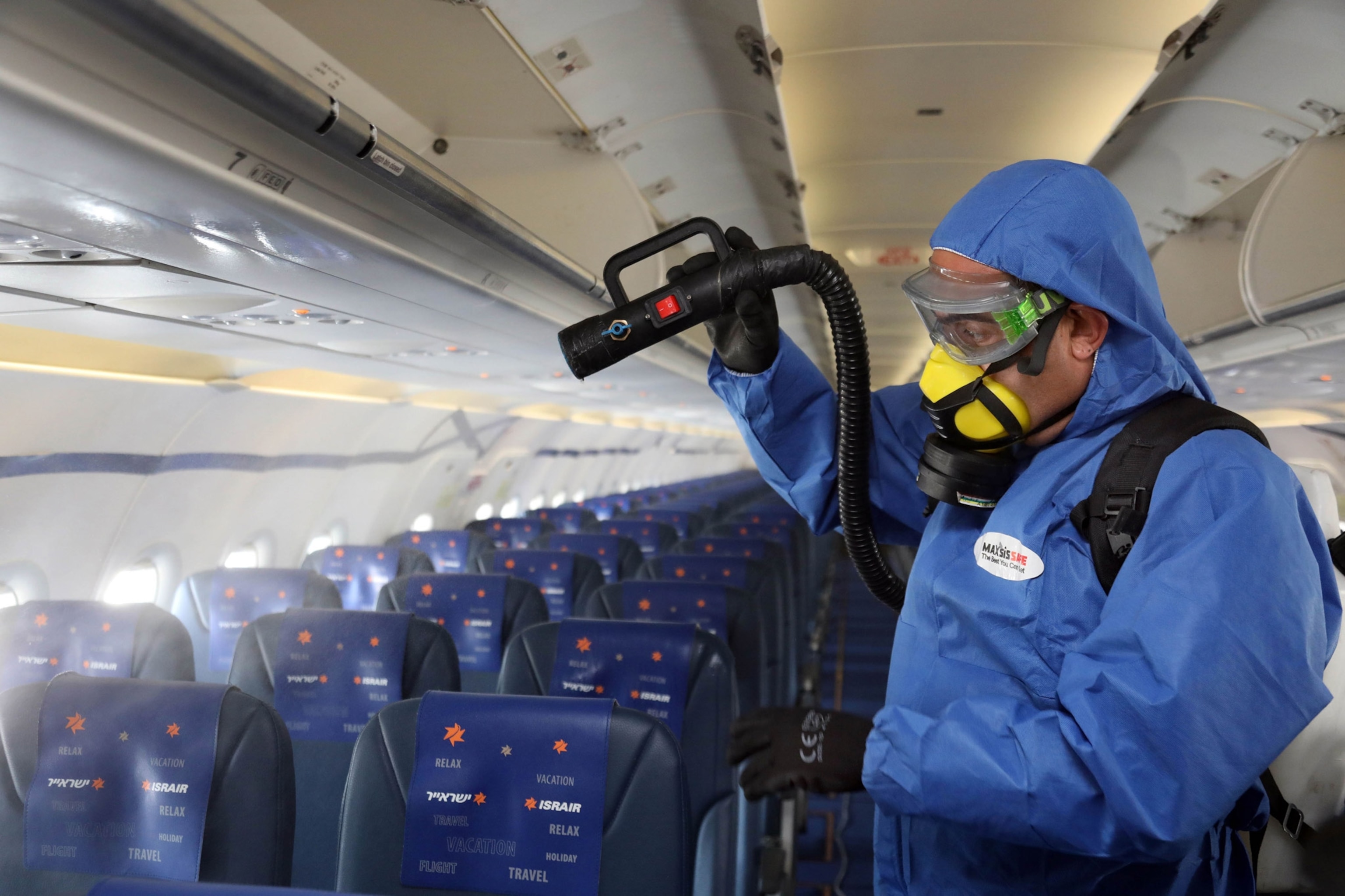 an Israeli worker wearing protective gears disinfects an Airbus