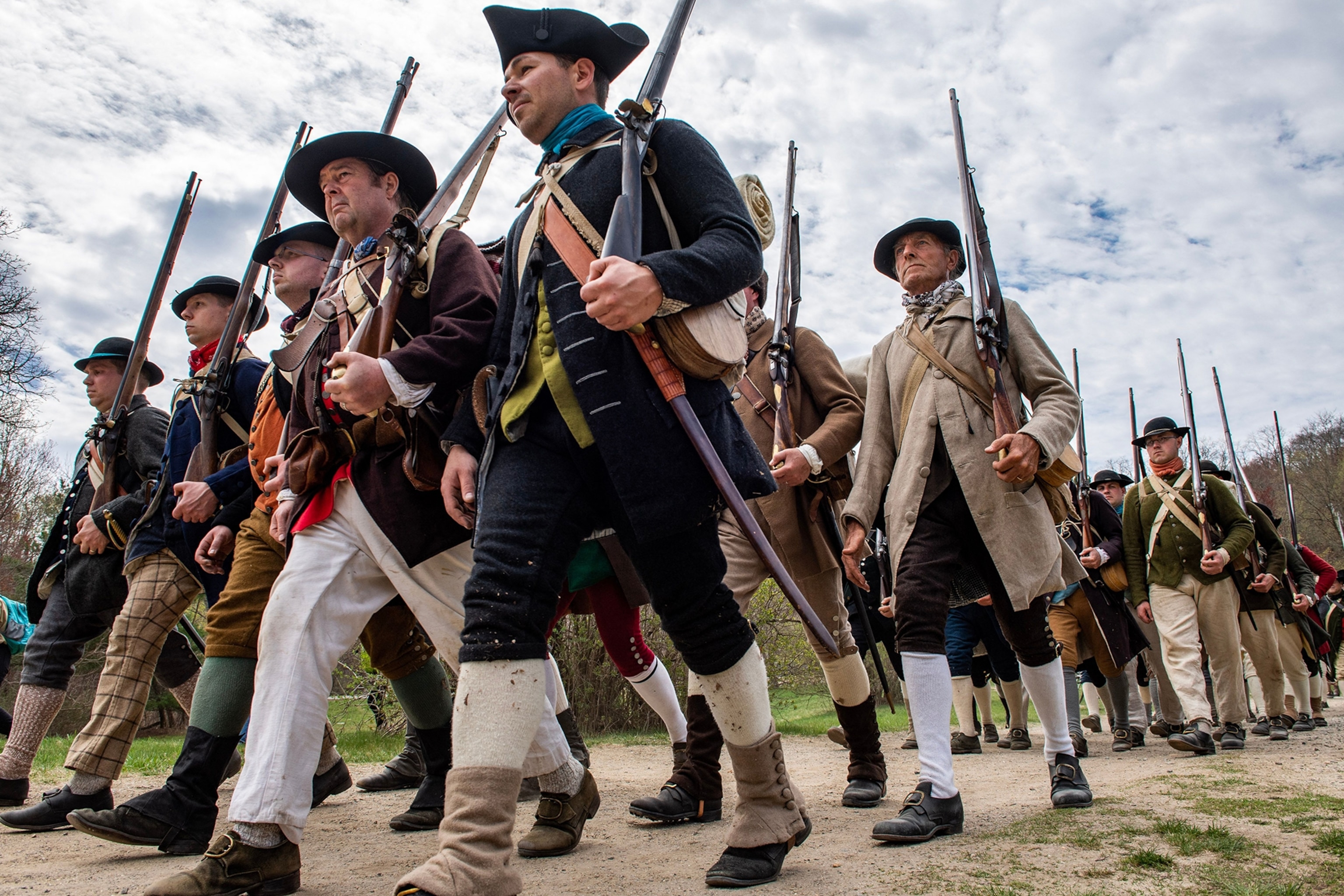 Hundreds of colonial militia reenactors march in formation during the Battle Road reenactment at Minute Man National Historical Park in Lincoln, Massachusetts on April 15, 2023. - The reenactment recounts the battle that immediately followed the Battle of Lexington and Concord on April 19, 1775. Re-enactors came from all over, some from England, some from Virginia and many from New England, to participate in the events of the day.