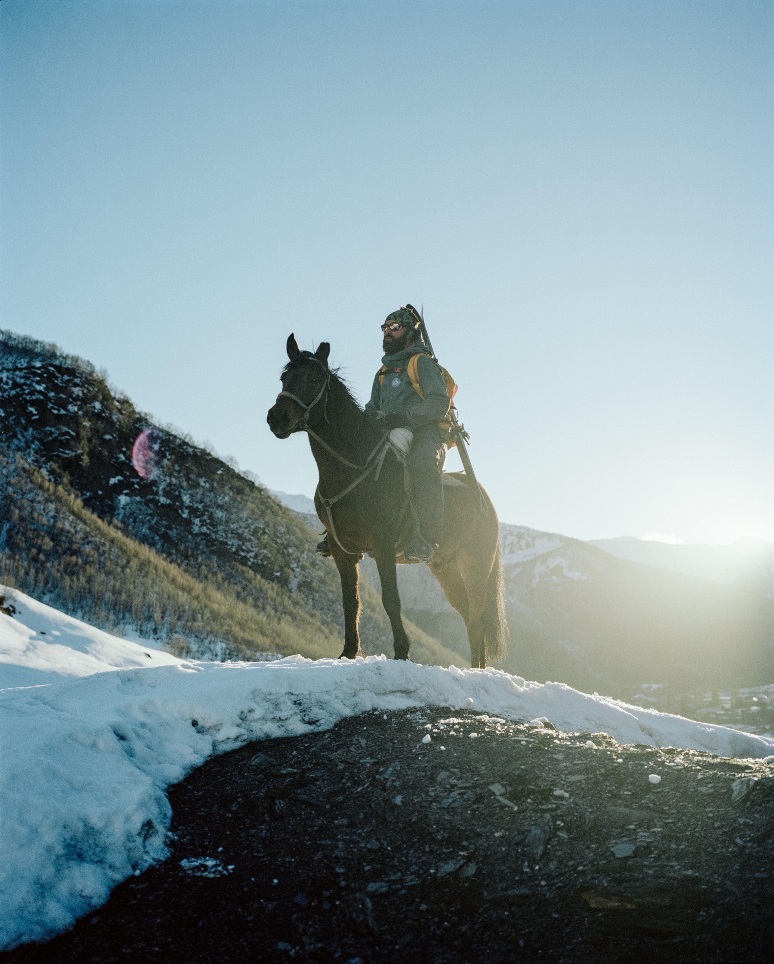 Mountain guide Lasha Pirtskhelani sits on top his horse for a portrait in the snow