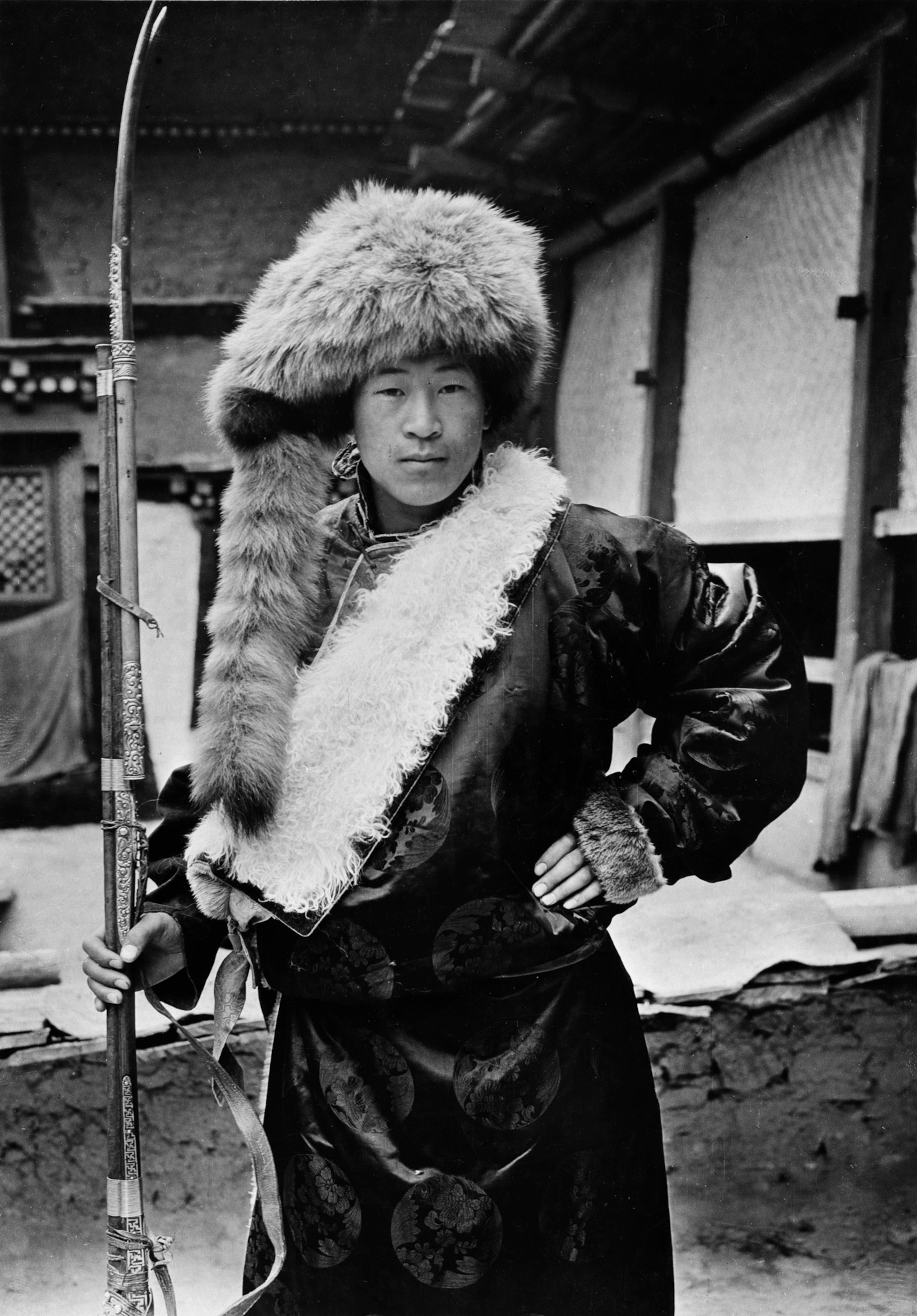Black and white photo of man posing with red panda hat