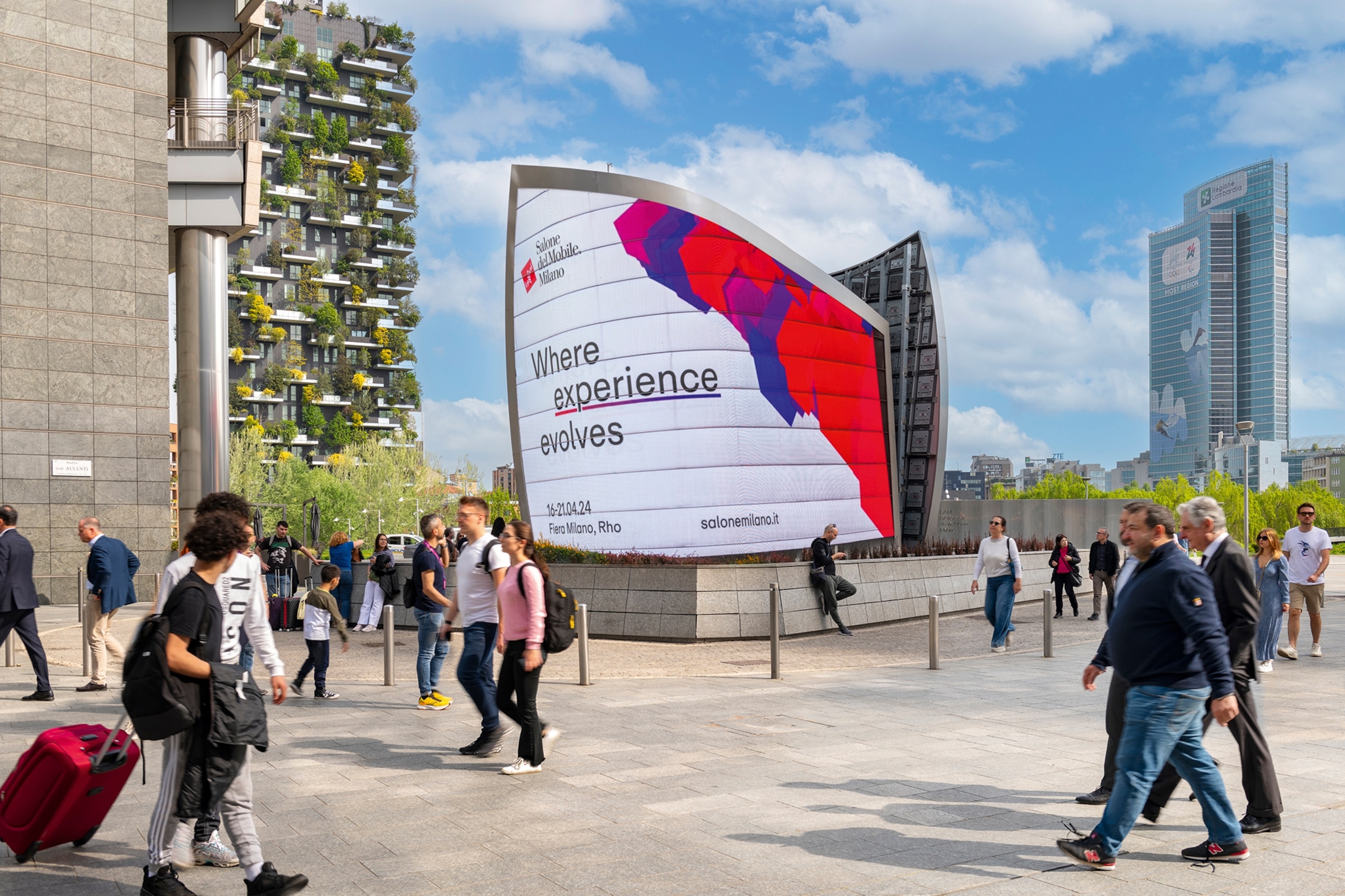 People walking past an illuminated billboard