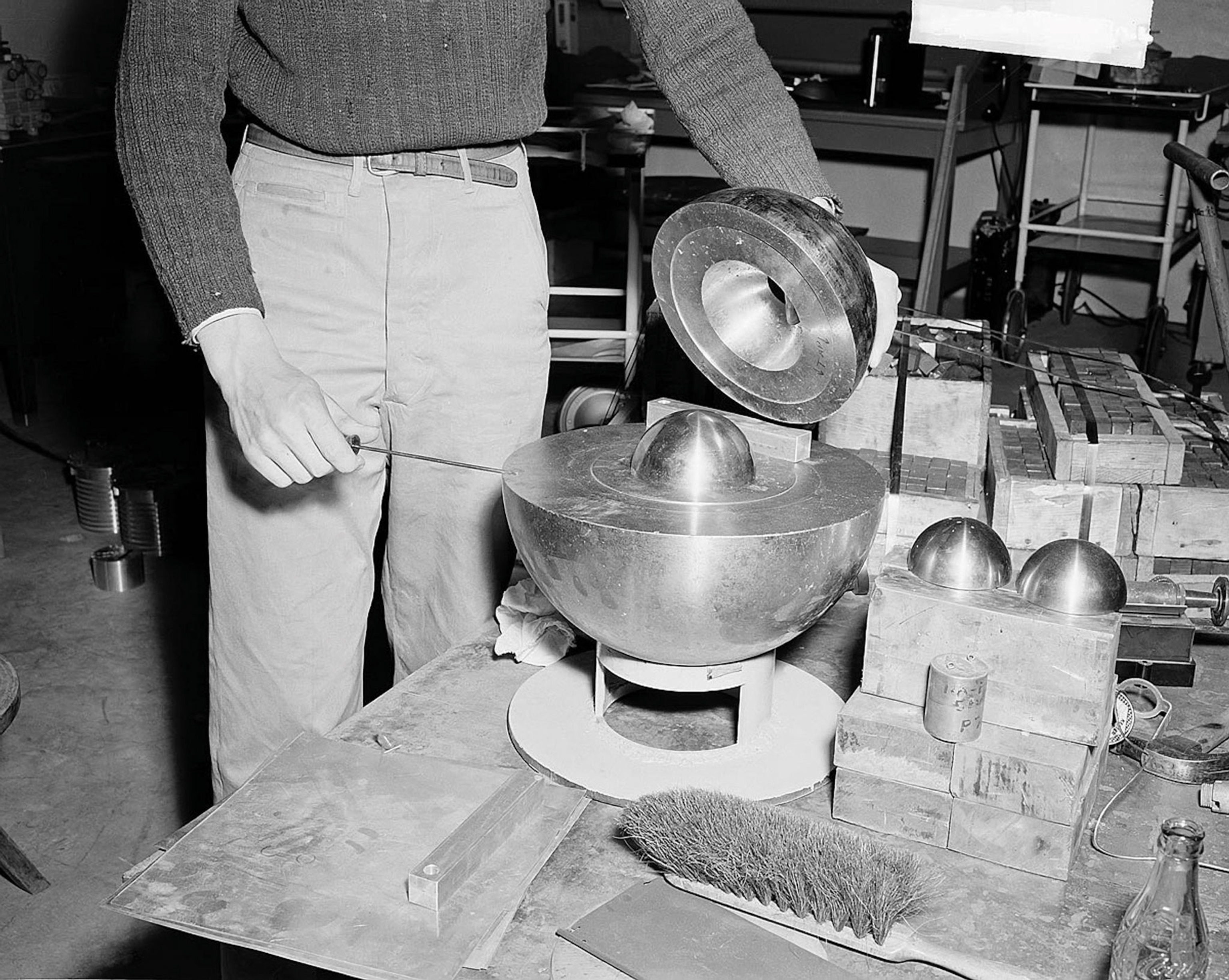 a man touching a metal sphere with a screwdriver