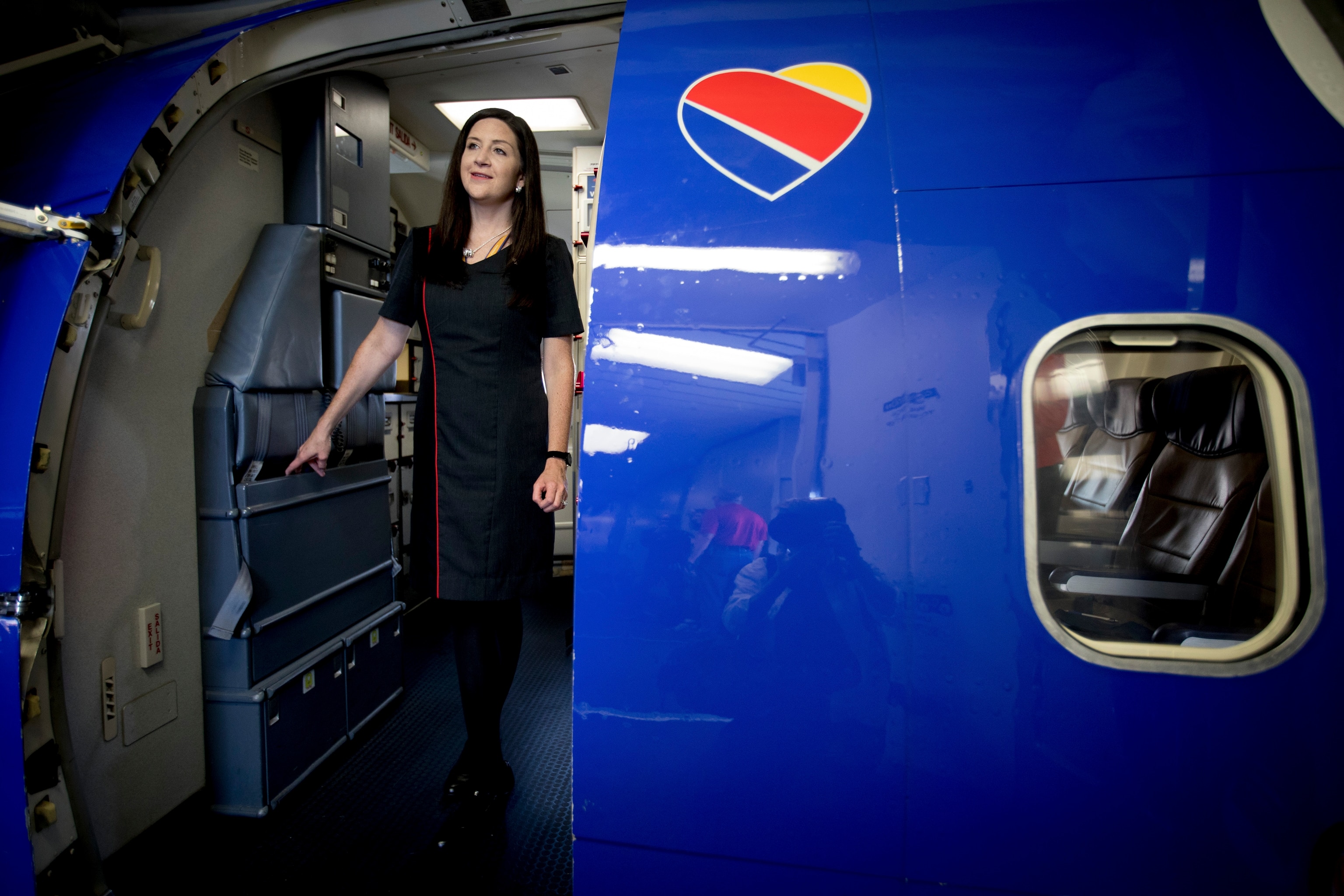 Ami Martin, a flight attendant for Southwest Airlines, waits for passengers boarding a flight at Love Field in Dallas
