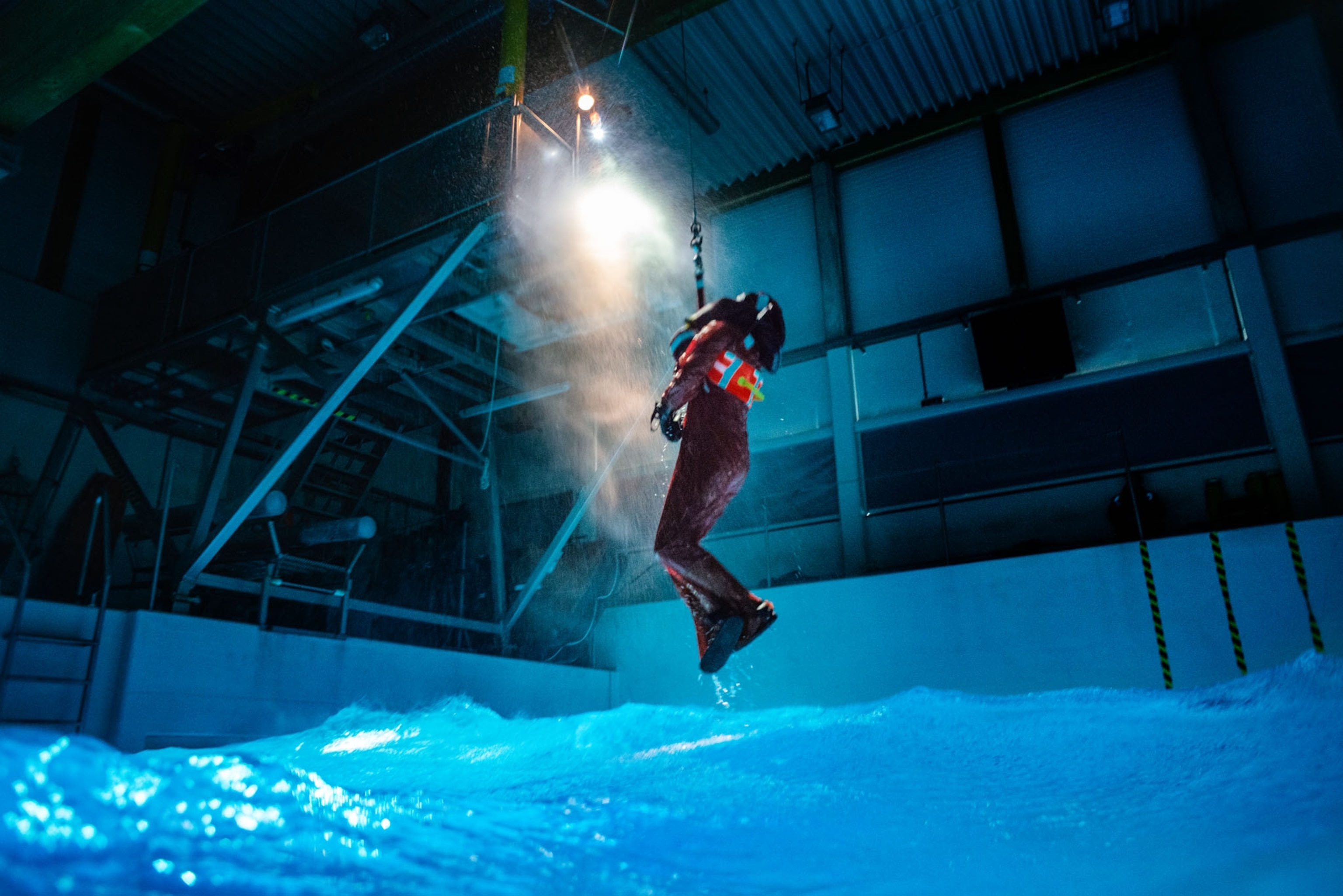 Picture of person suspended into a safety hornest and is witched up, simulating a helicopter rescue.