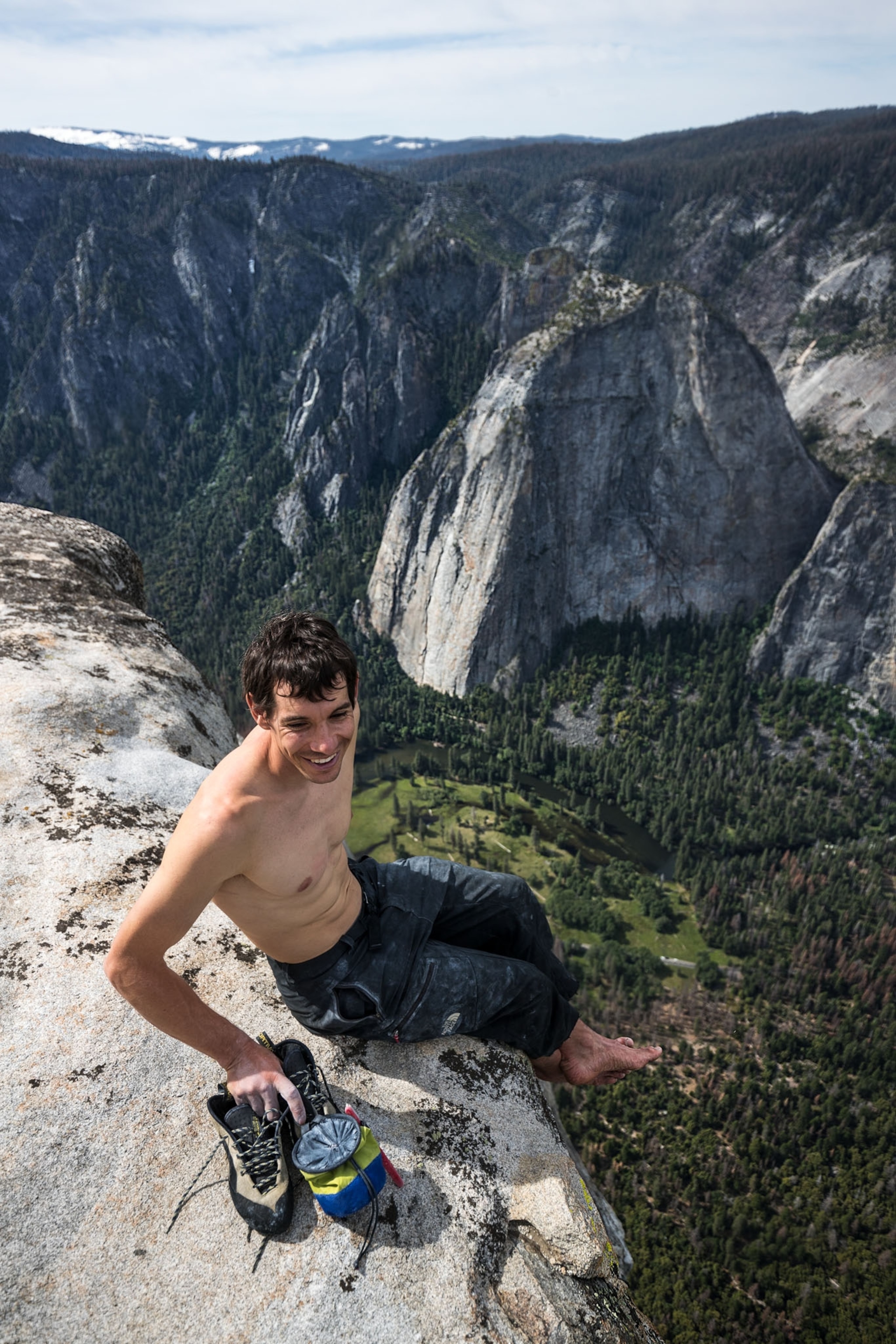 a man sitting at the edge of a mountain