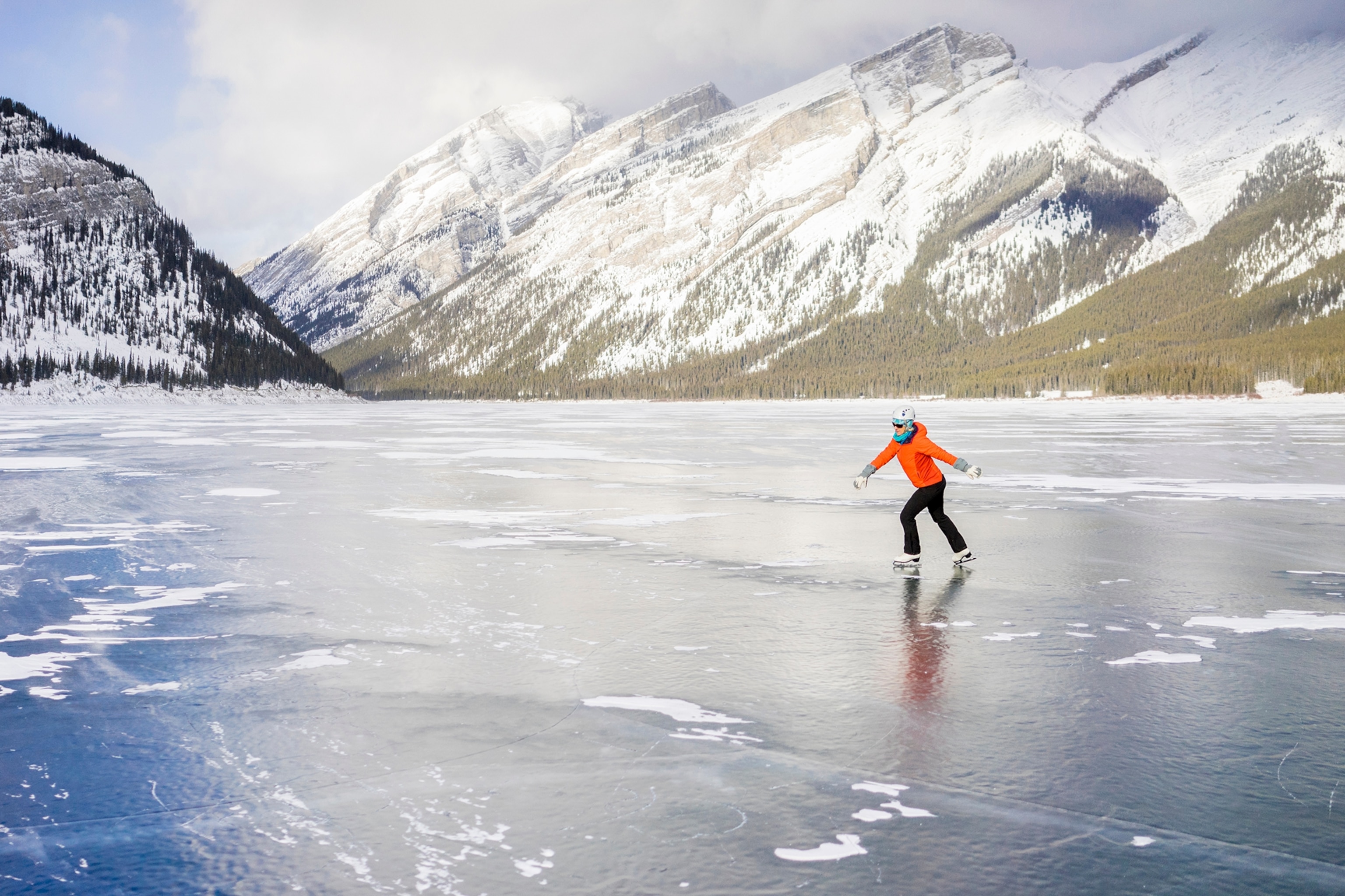 A skater doing rounds on a frozen lake in the Canadian Rockies