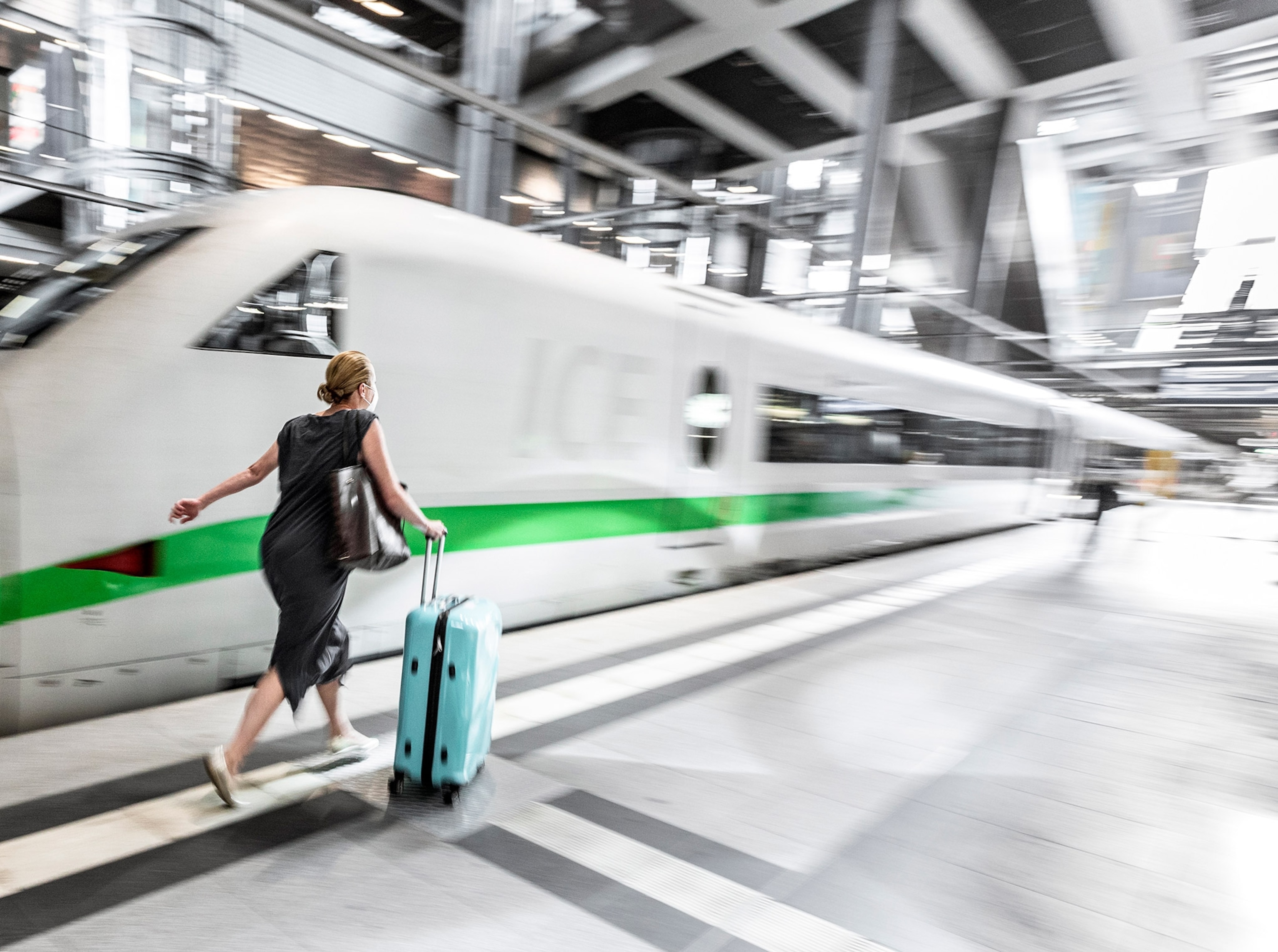 a person hurrying with a suitcase to board a train at the Central Station in Berlin, Germany