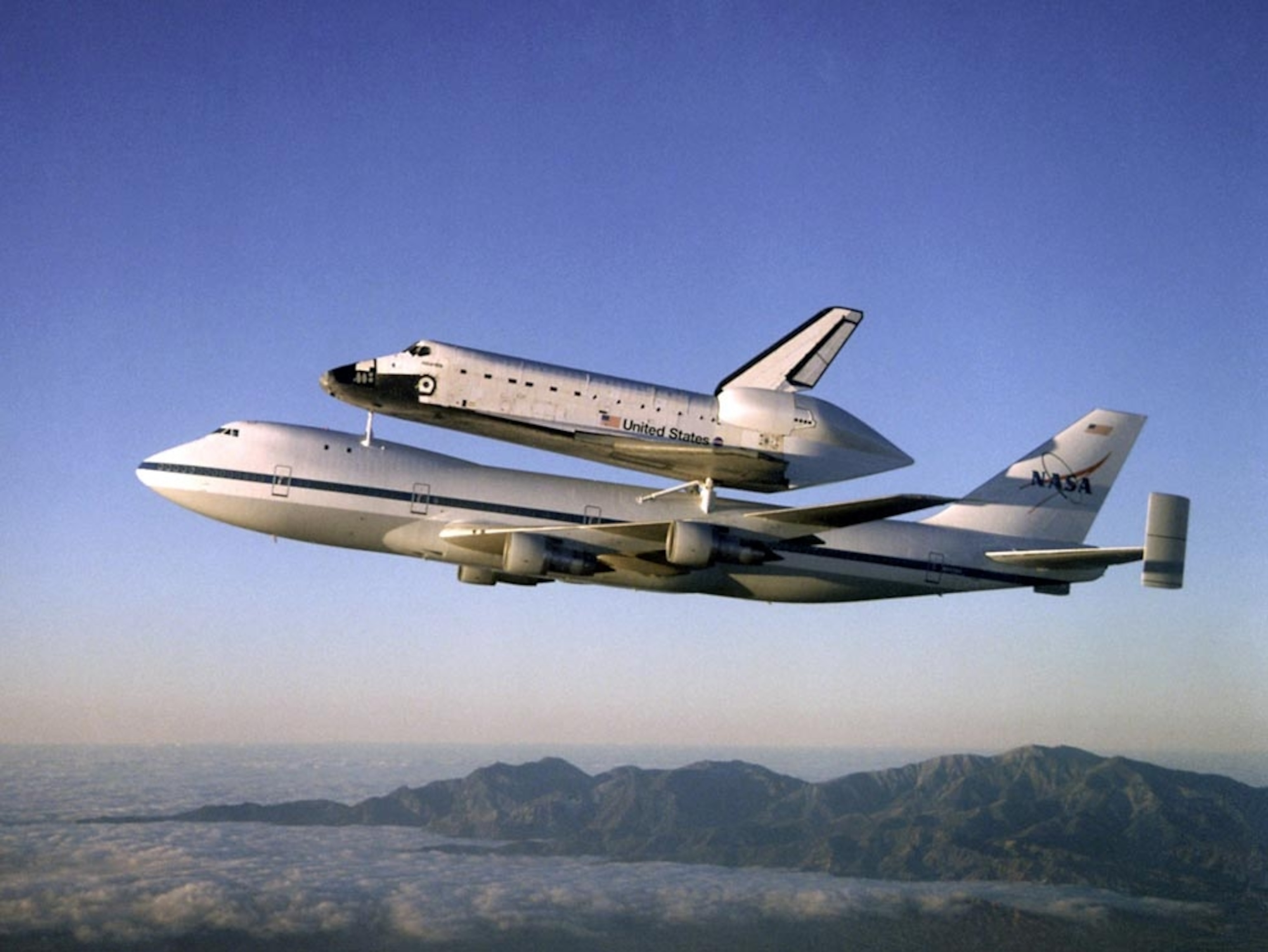 an airplane ferrying a space shuttle in air