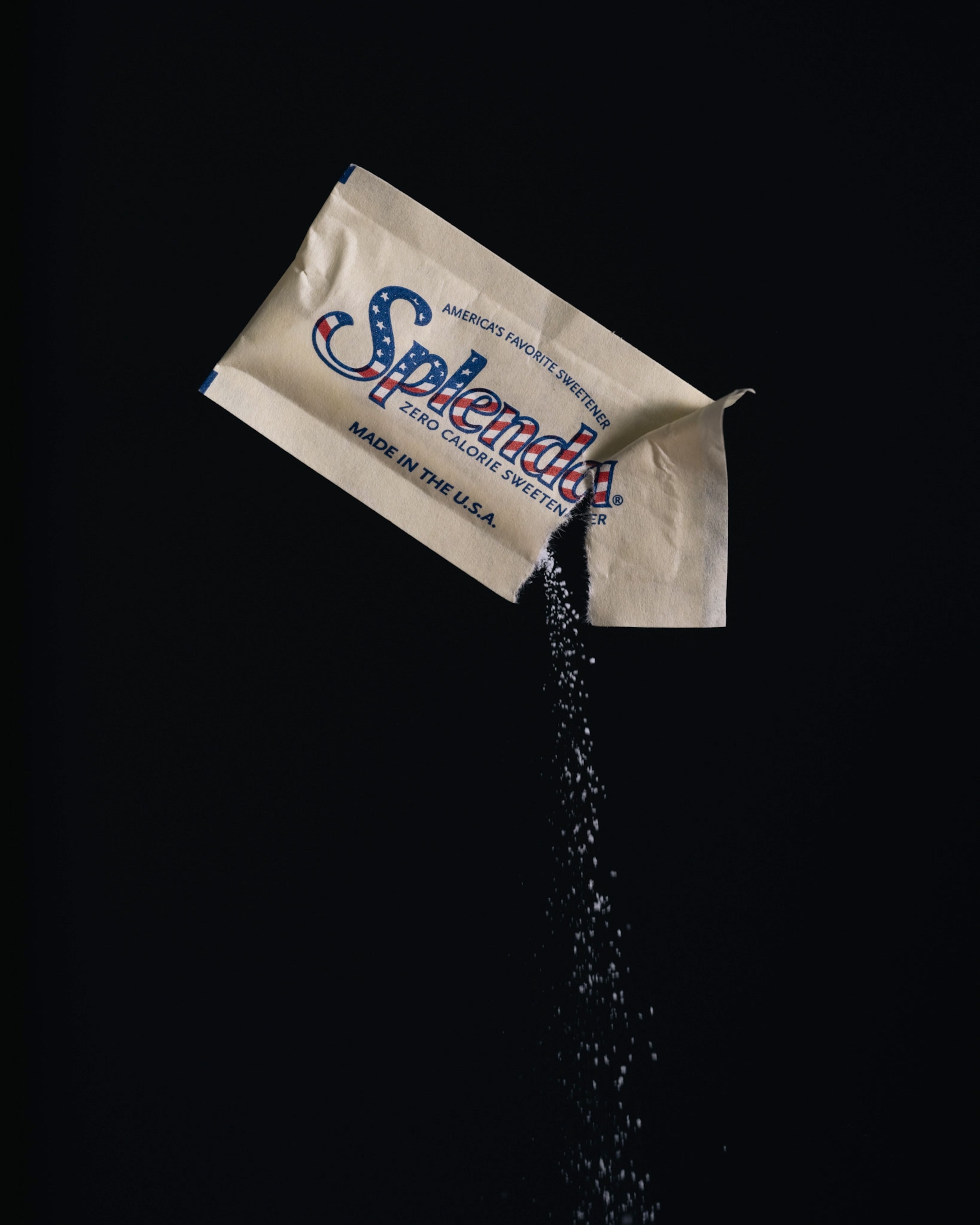 Studio shoot with black backdrop showing packets of artificial sweeteners