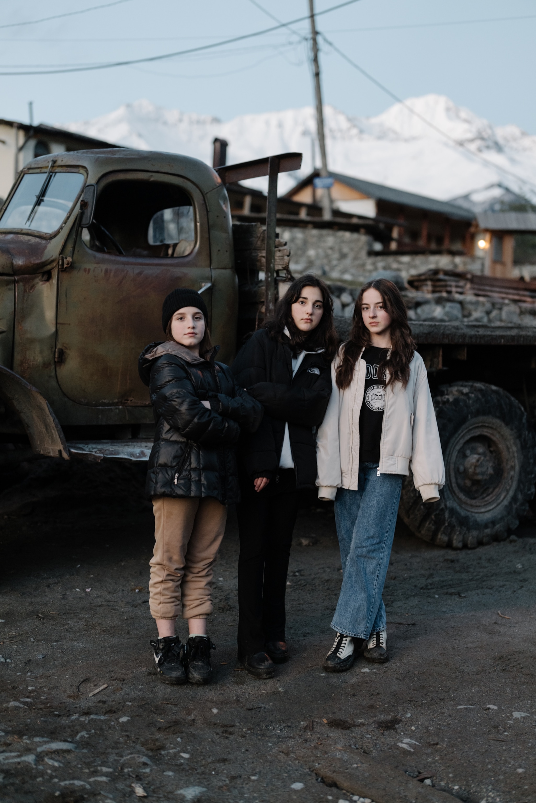 A portrait of three young girls standing together in Mestia