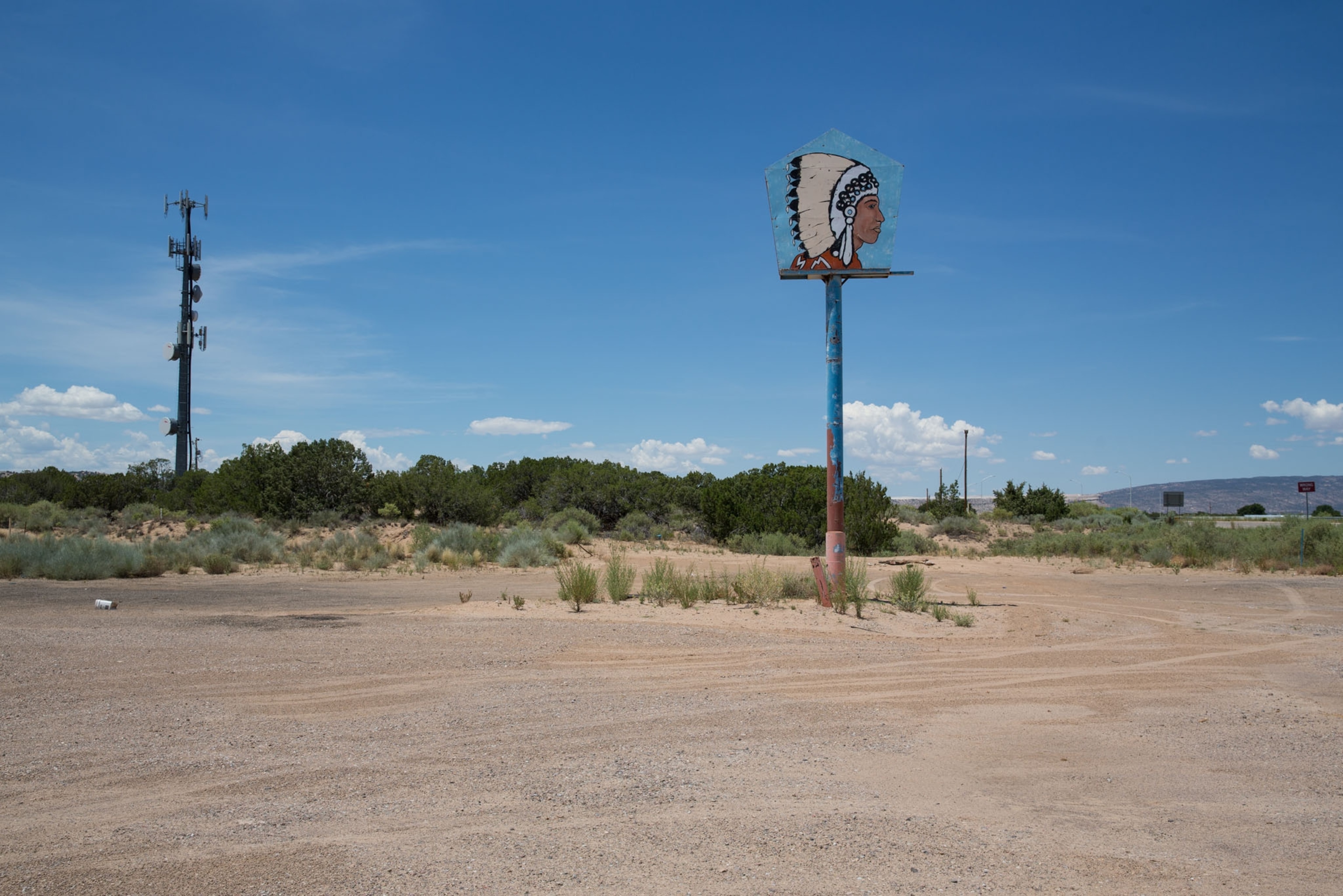 a sculpture depicting a commercial image of a native American by a defunct gas station