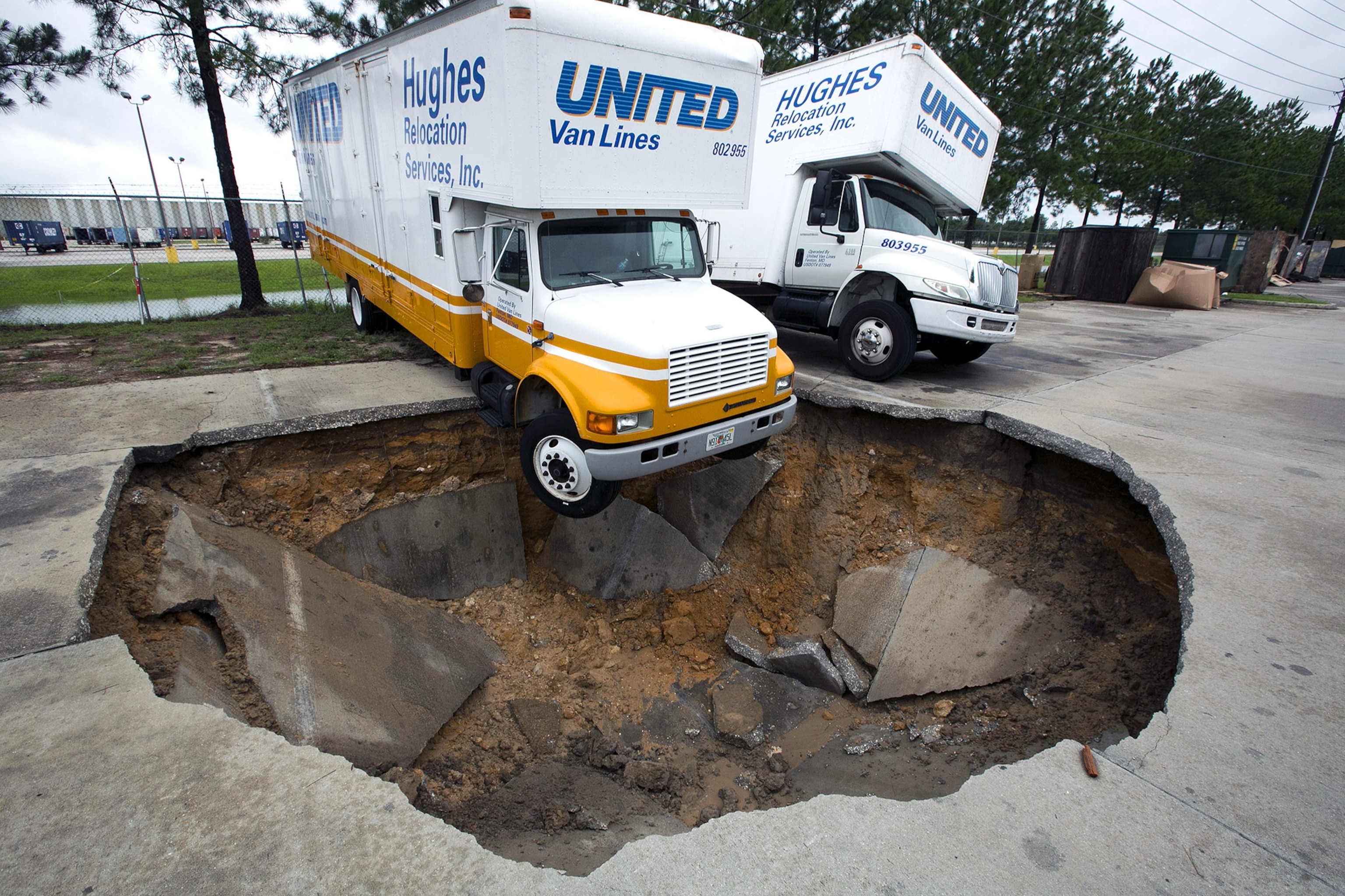 Kim Russell, left, who lives nearby on Gilbralter Street and her mother Betty Box both examine the massive sinkhole that opened on Eldridge Road in Spring Hill, Fla., Saturday. T