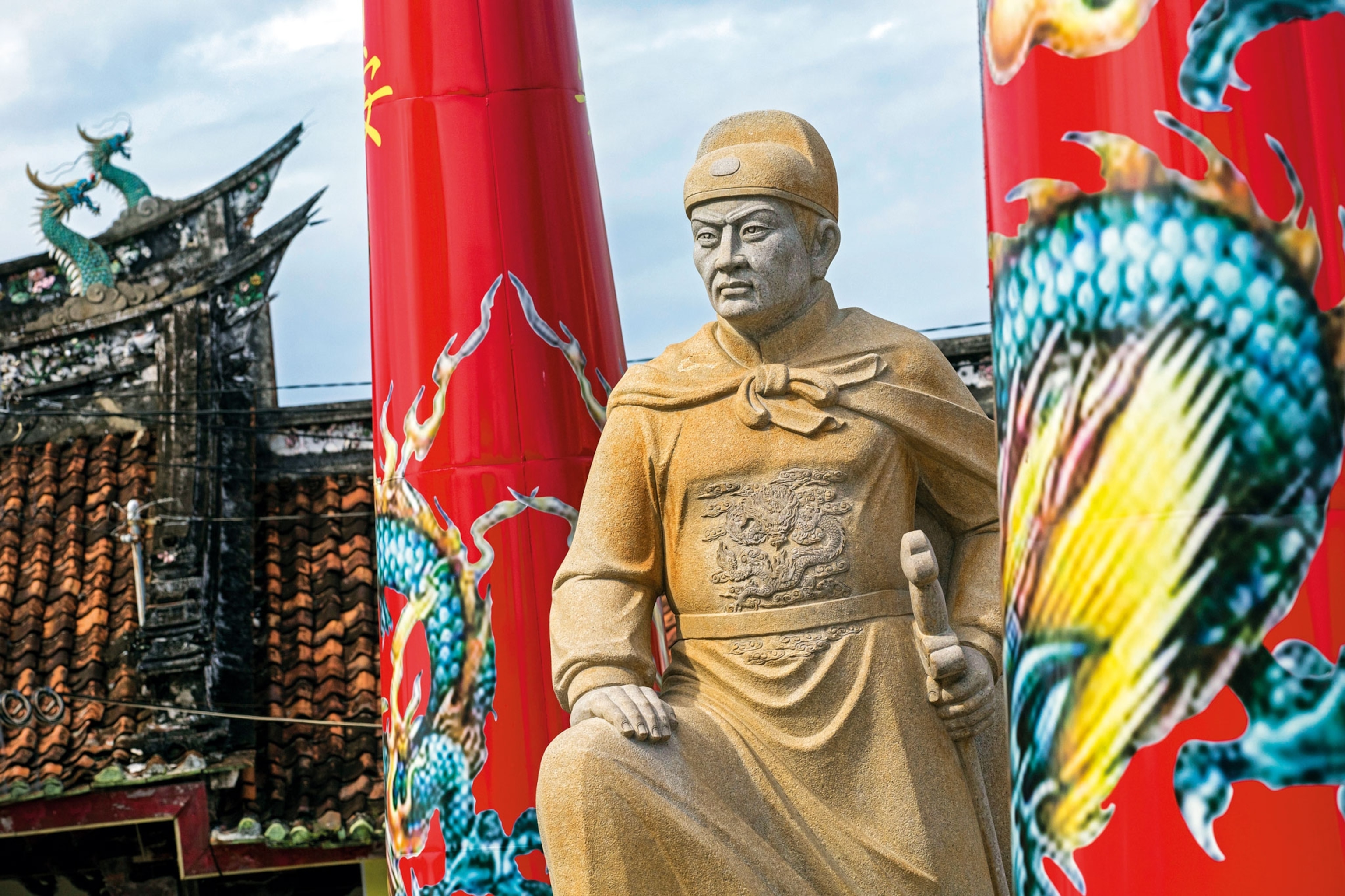 a statue of a man wearing a cape and holding a sword