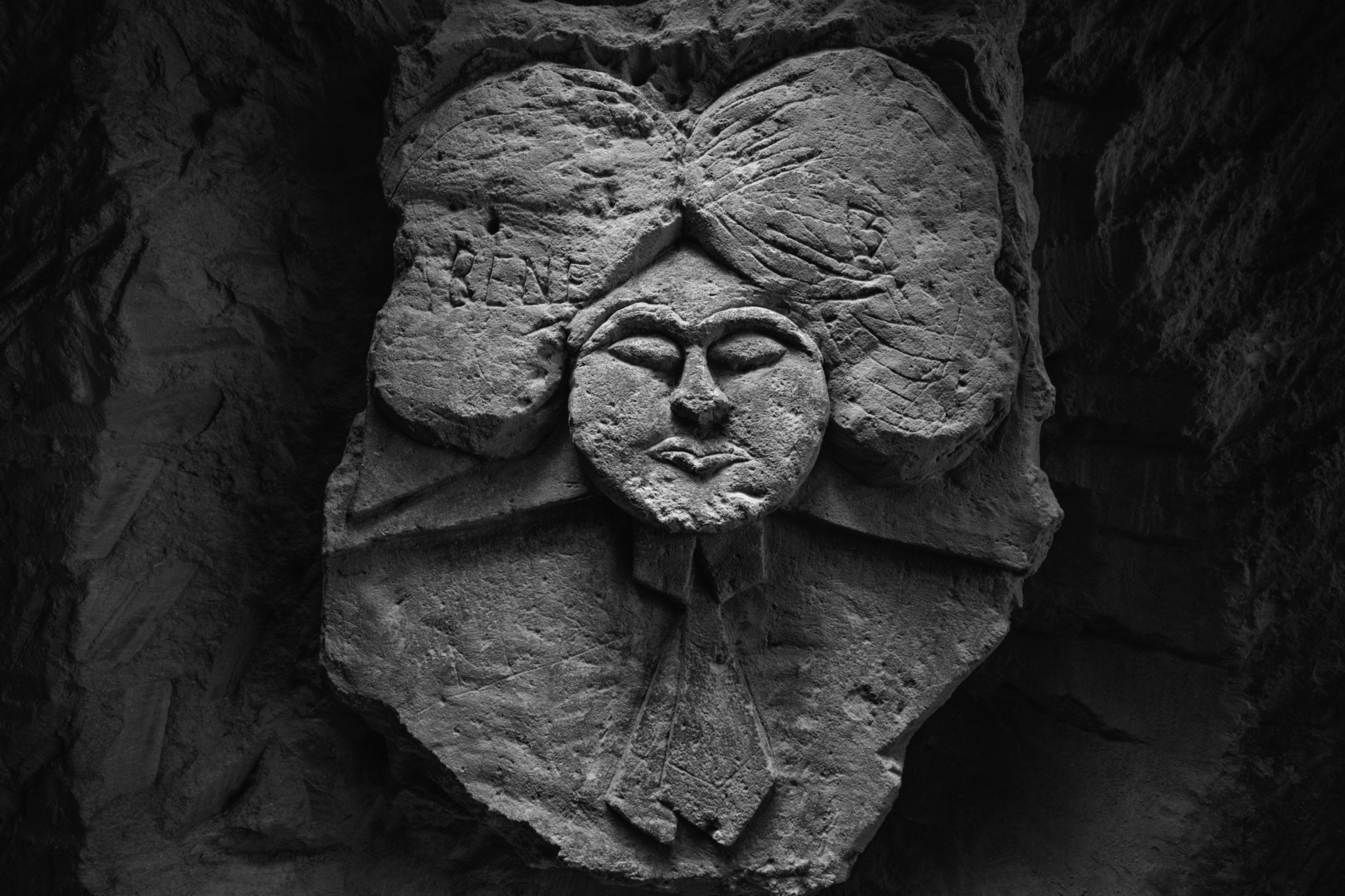 a carving of a woman wearing large hair bows