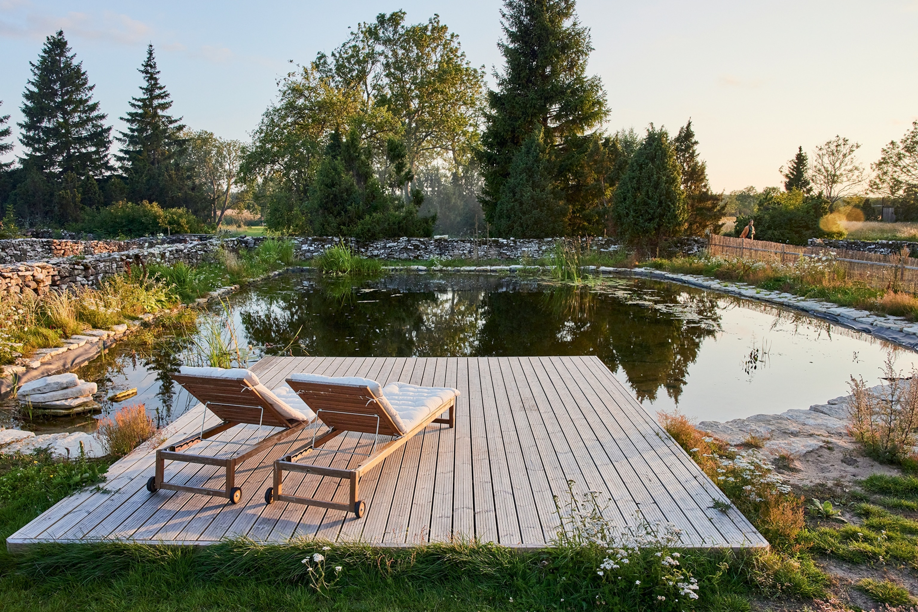 two lounge chairs by the water