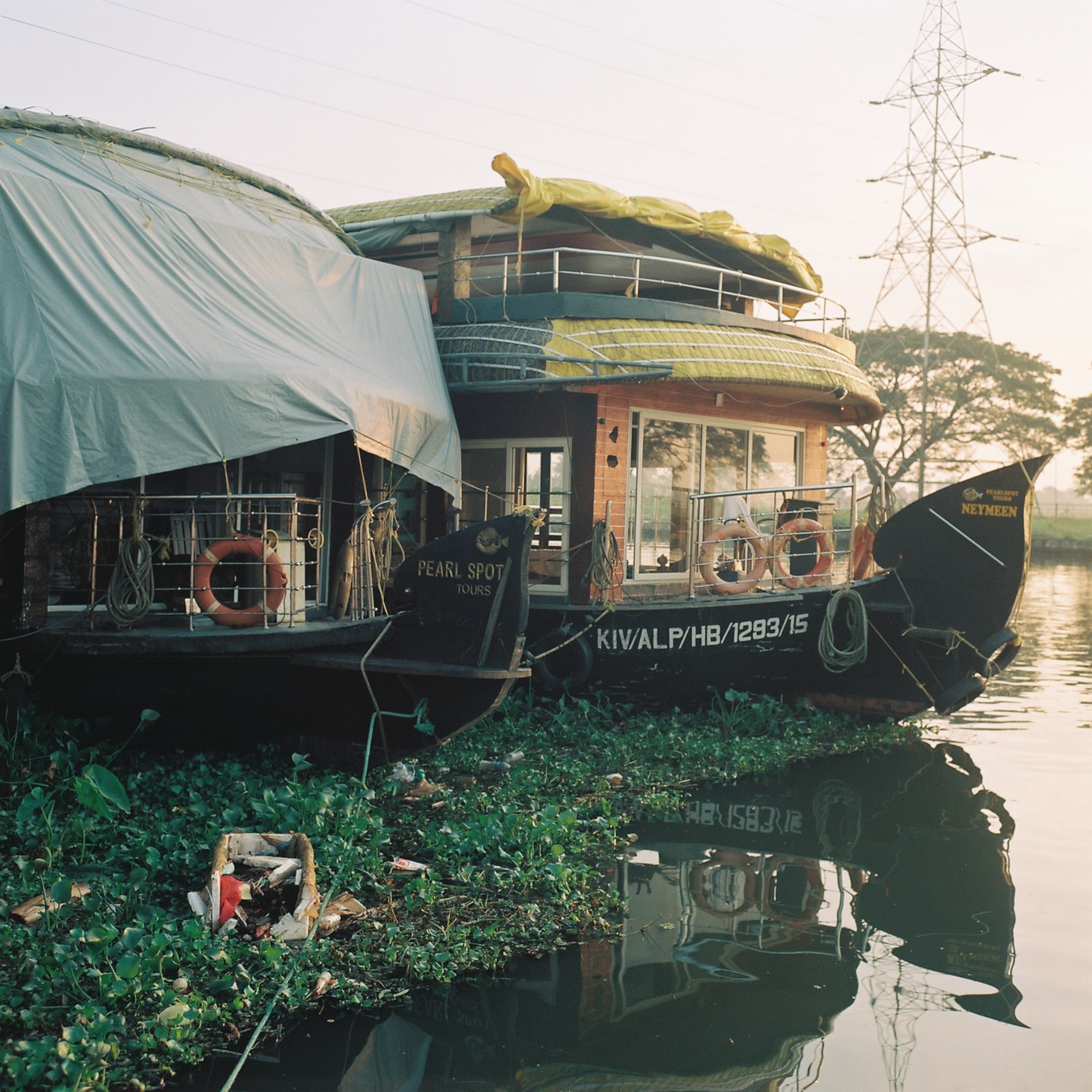 Boats are seen docked at sunrise on Vembanad Lake