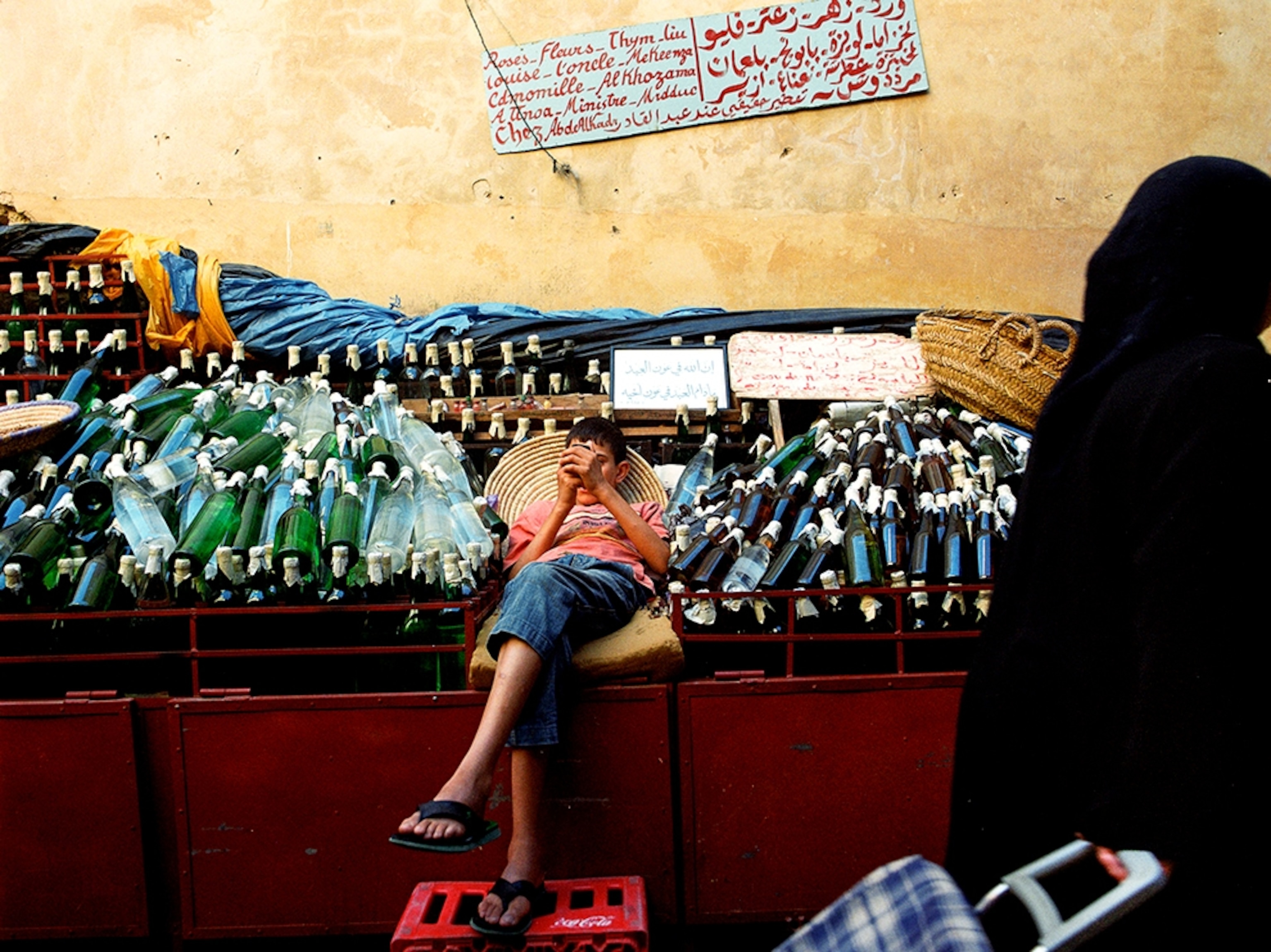 a boy checking his cell phone at a souk in Fez, Morocco