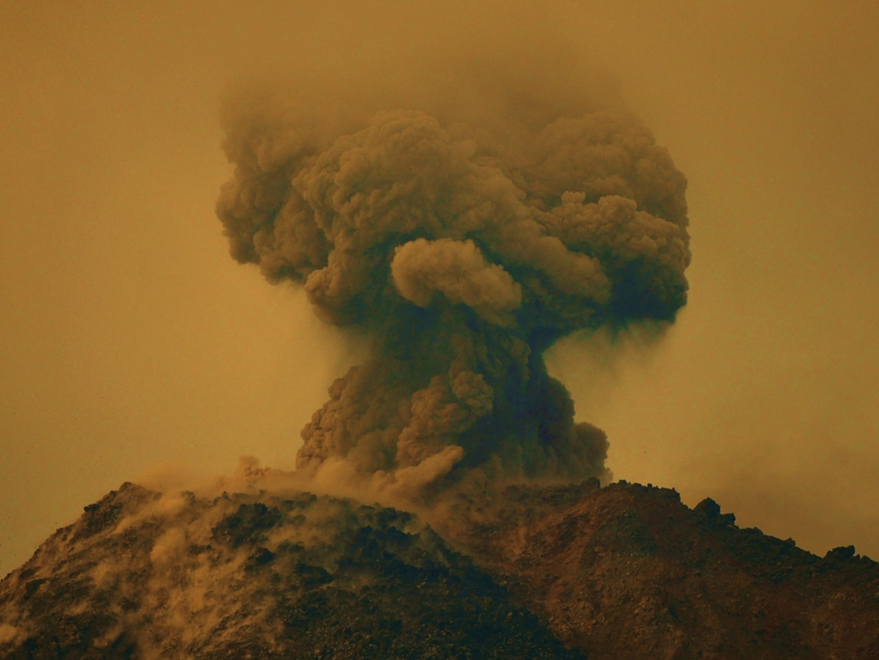 Ash plume rising from the top of a mountain