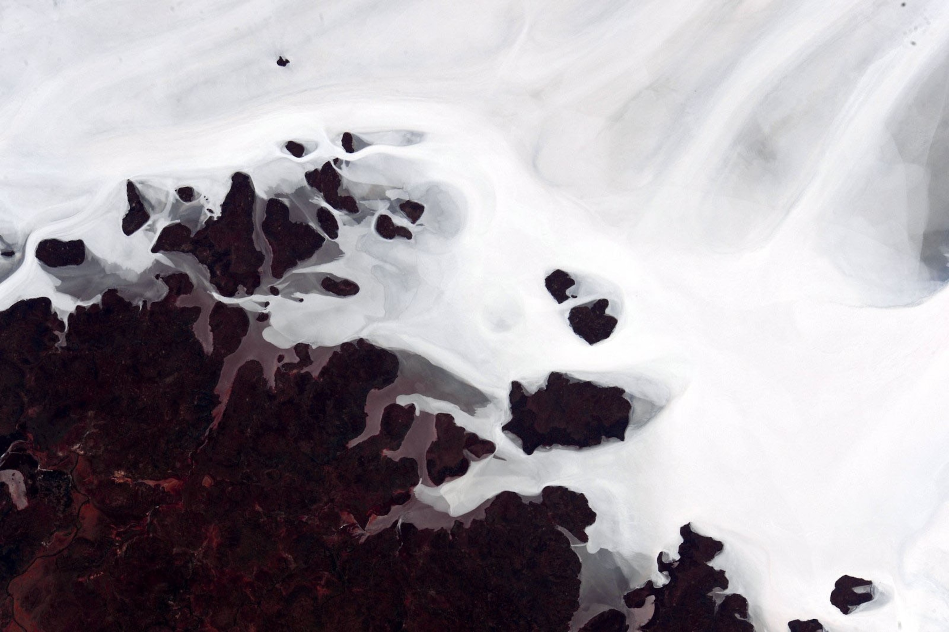 aerial view of white and brown masses flooding one another