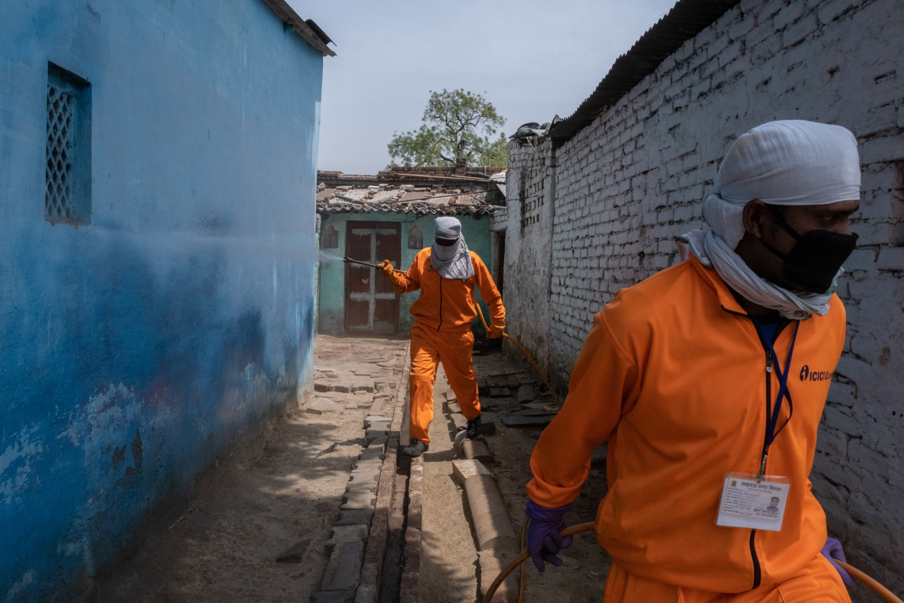 two people covered in bright orange suits walking outside